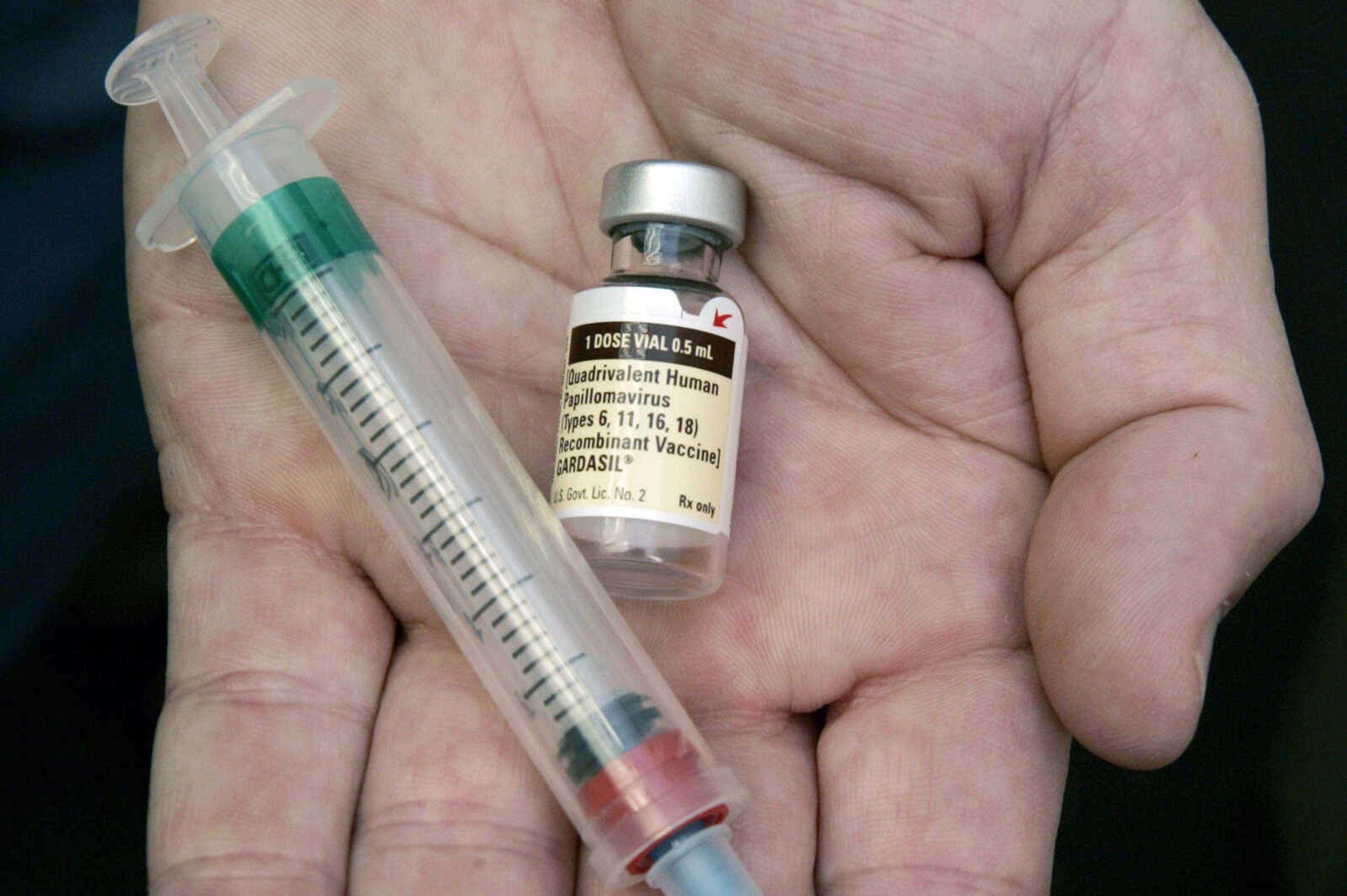 A doctor holds a vial of the human papillomavirus (HPV) vaccine Gardasil on Aug. 28, 2006, in his Chicago office.