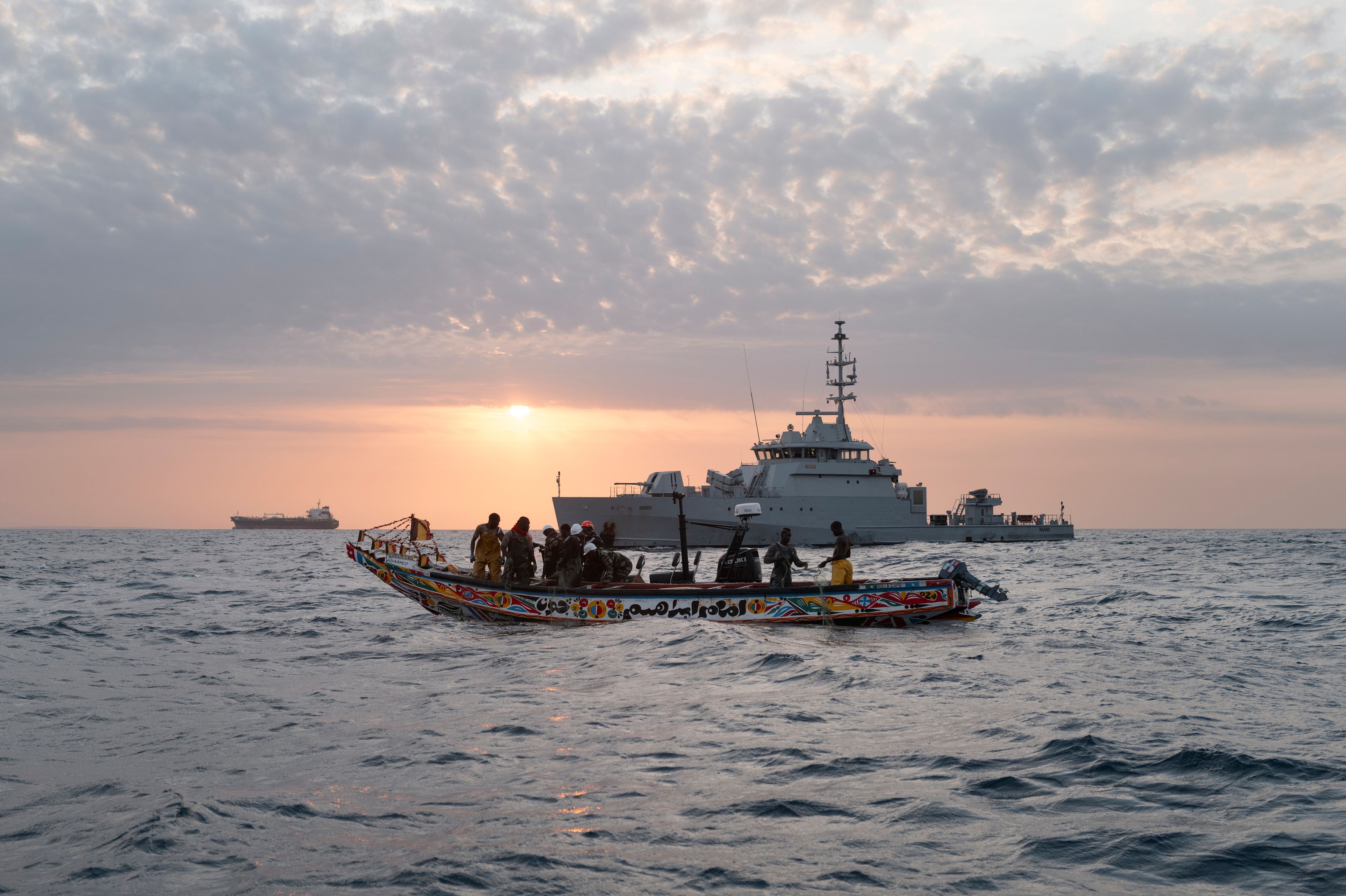 Senegalese sailors on their zodiac, background, approach a fishermen's pirogue to check during a mission to search for illegal migrant boats near the coast of Dakar, Senegal, Saturday, Nov.16, 2024. (AP Photo/Sylvain Cherkaoui)