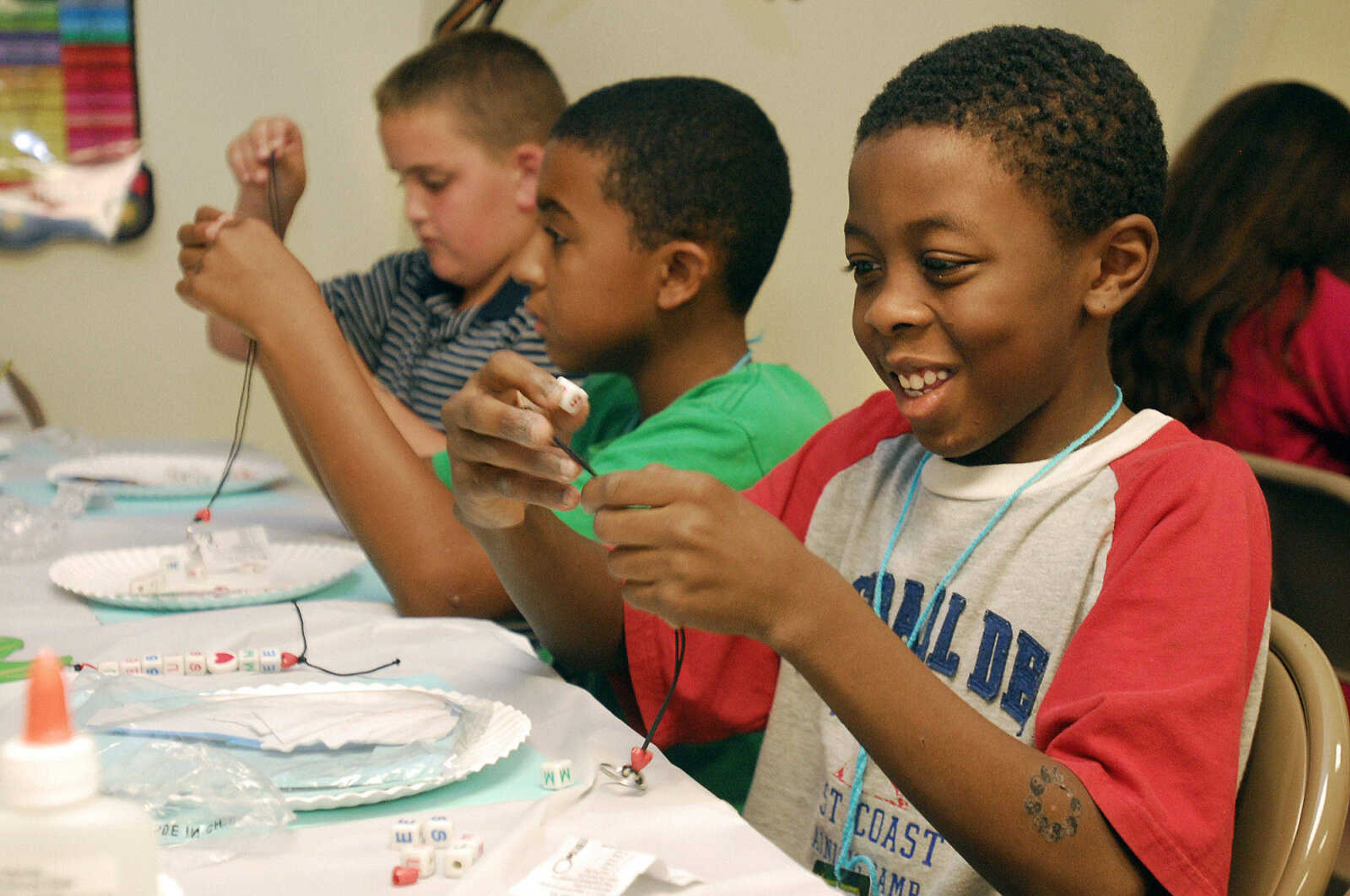 LAURA SIMON~lsimon@semissourian.com
Dajon Glass, front, Brian Schumer, center, and Zachary McHughs string beads during the arts and crafts portion of VBS at Lighthouse Bible Baptist Church in Cape Girardeau Tuesday, August 3, 2010.