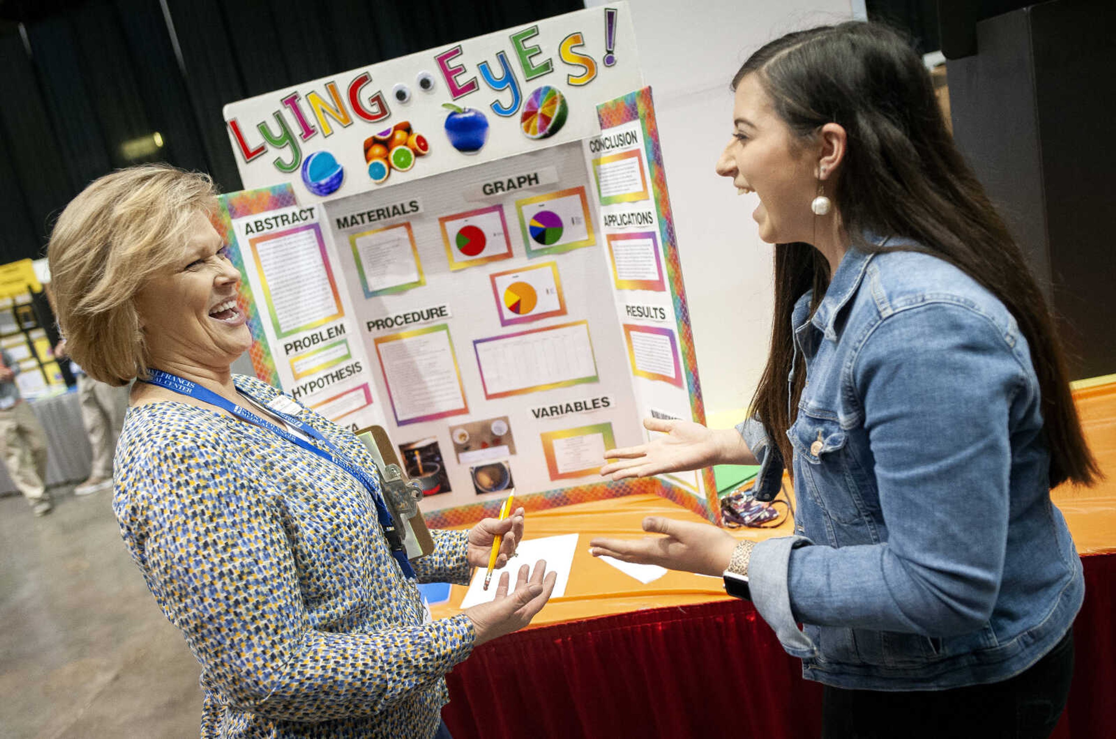 Laura Delgado of Cape Girardeau, with Southeast Missouri State University's department of psychology, and Lindsey Lancaster, a freshman at Malden High School, share a moment while discussing Lancaster's project during the 64th annual Southeast Missouri Regional Science Fair on Tuesday, March 10, 2020, at the Show Me Center in Cape Girardeau. Lancaster said her project deals with analyzing if the color of food affects one's perception of how it tastes.