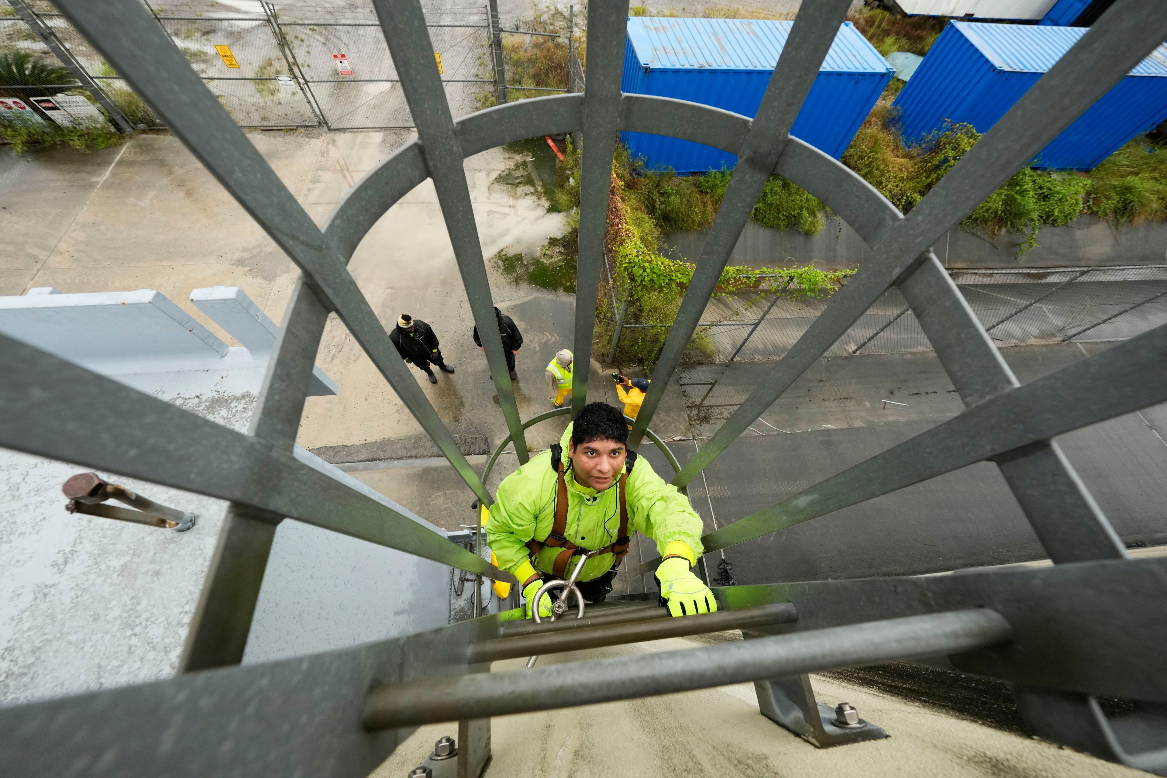 Delwyn Bodden, a worker for the Southeast Louisiana Flood Protection Authority-West climbs a ladder up a floodgate to lock it closed along the Harvey Canal, just outside the New Orleans city limits, in anticipation of Tropical Storm Francine, in Harvey, La., Tuesday, Sept. 10, 2024. (AP Photo/Gerald Herbert)