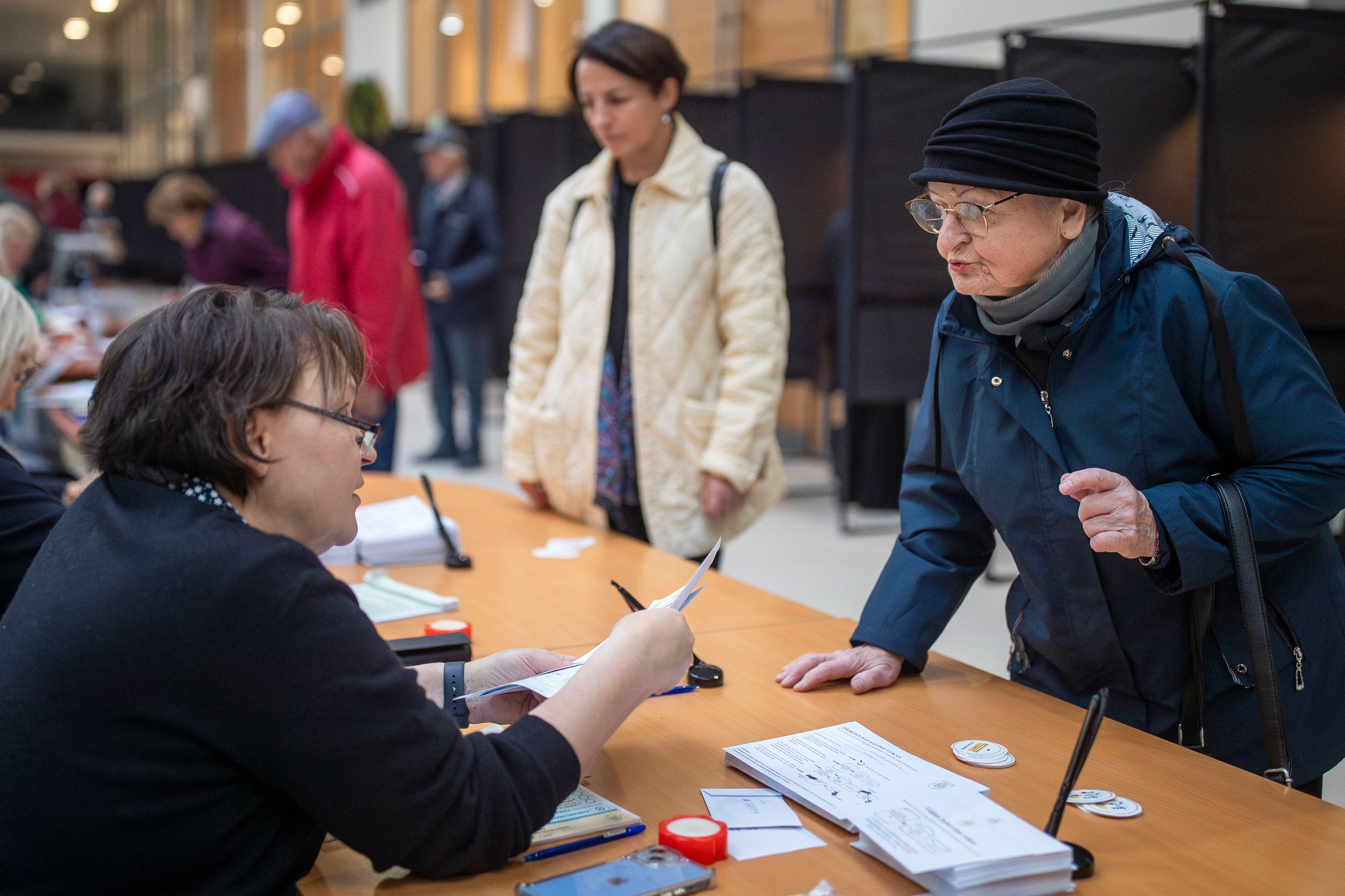 A woman arrives at a polling station during the advance voting in the first round of a parliamentary election in Vilnius, Lithuania, Wednesday, Oct. 9, 2024. (AP Photo/Mindaugas Kulbis)