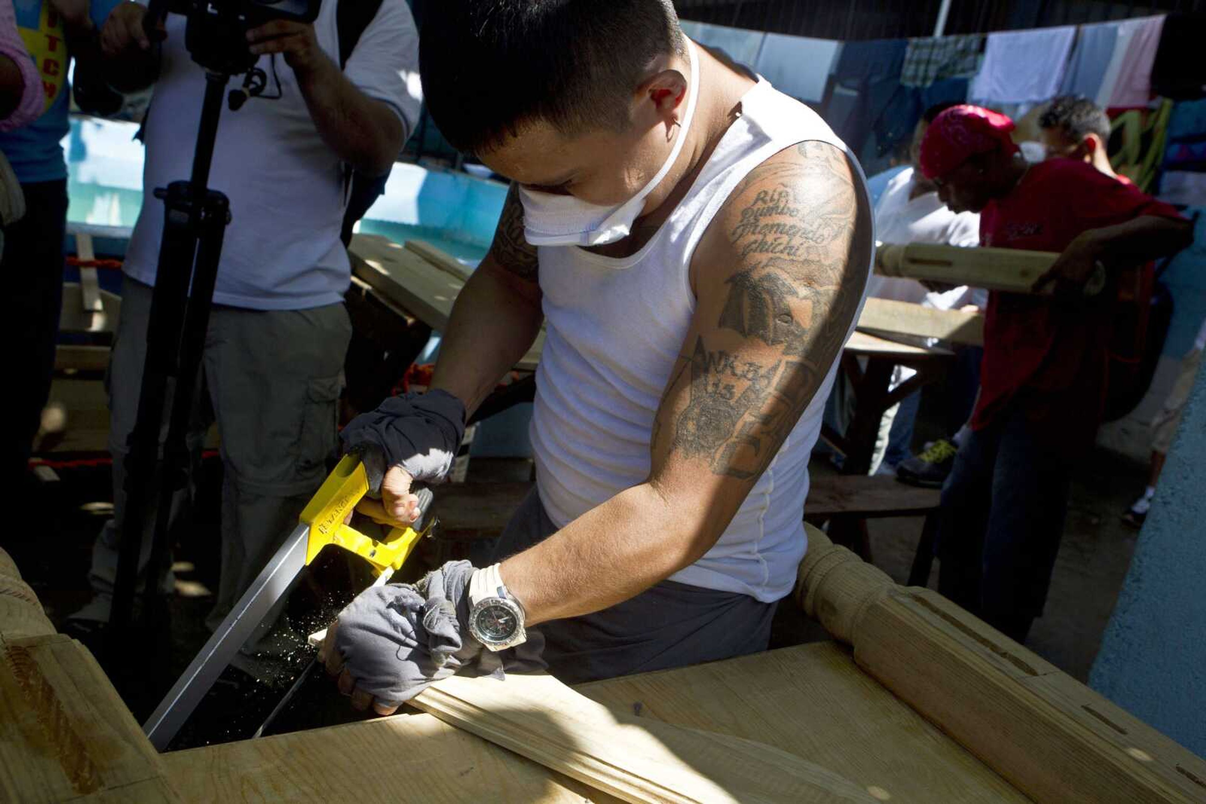 A gang member cuts wood as he works in a carpentry workshop inside the San Pedro Sula prison in Honduras. Honduras&#8217; largest and most dangerous street gangs have declared a truce, offering the government peace in exchange for rehabilitation and jobs. (Estaban Felix ~ Associated Press)