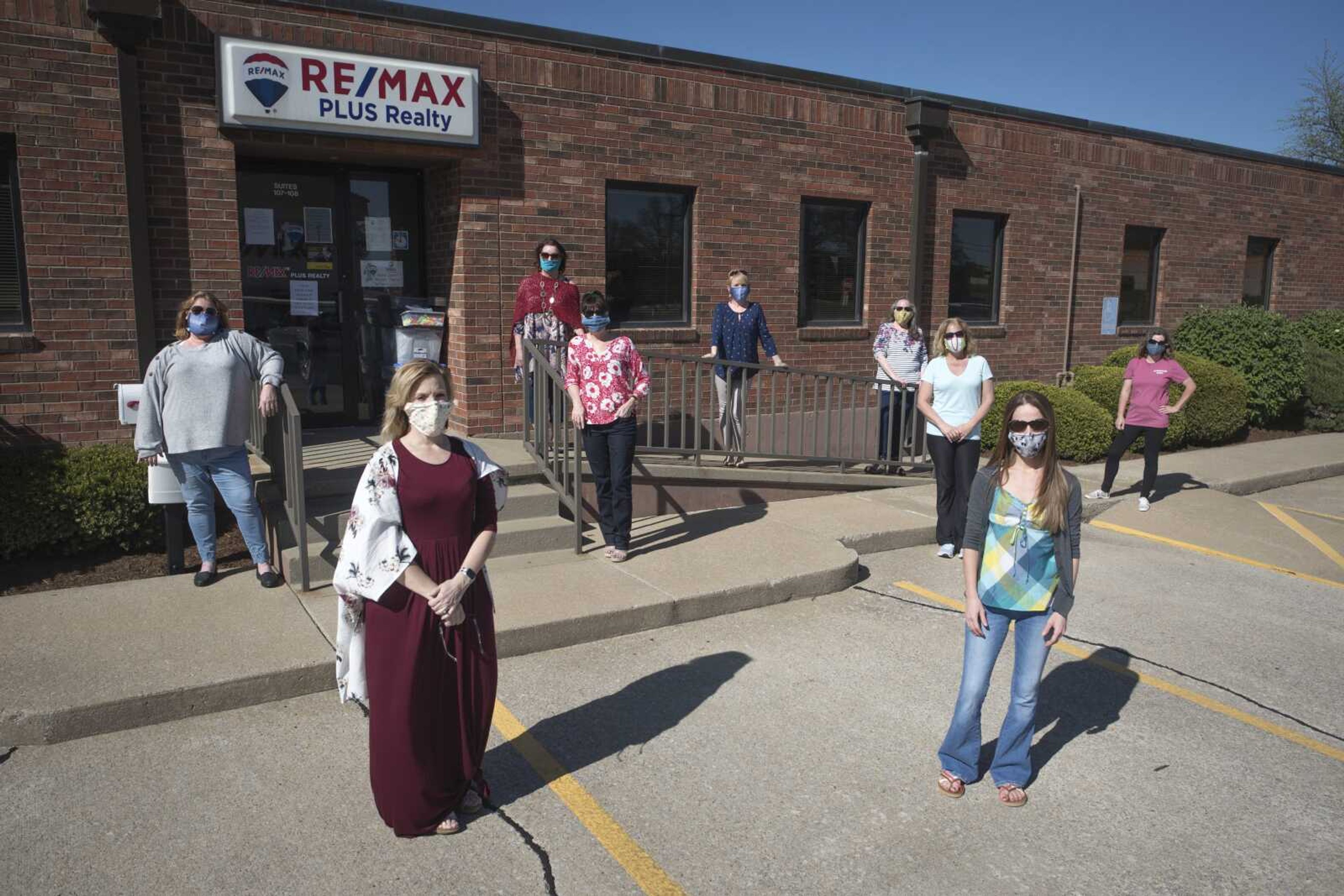 Members of a newly formed online group to produce face masks pose for a photo while following recommended guidelines for social distancing Tuesday outside of RE/MAX Plus Realty in Cape Girardeau. Group members pictured, from left, are Amanda Evans, Wendy Link, Shari McConnell, Melissa Glover, Wendy Flynn, Janelle Tingle, Shelly Stone, Lisa Sanchez and Hillary Corjos.