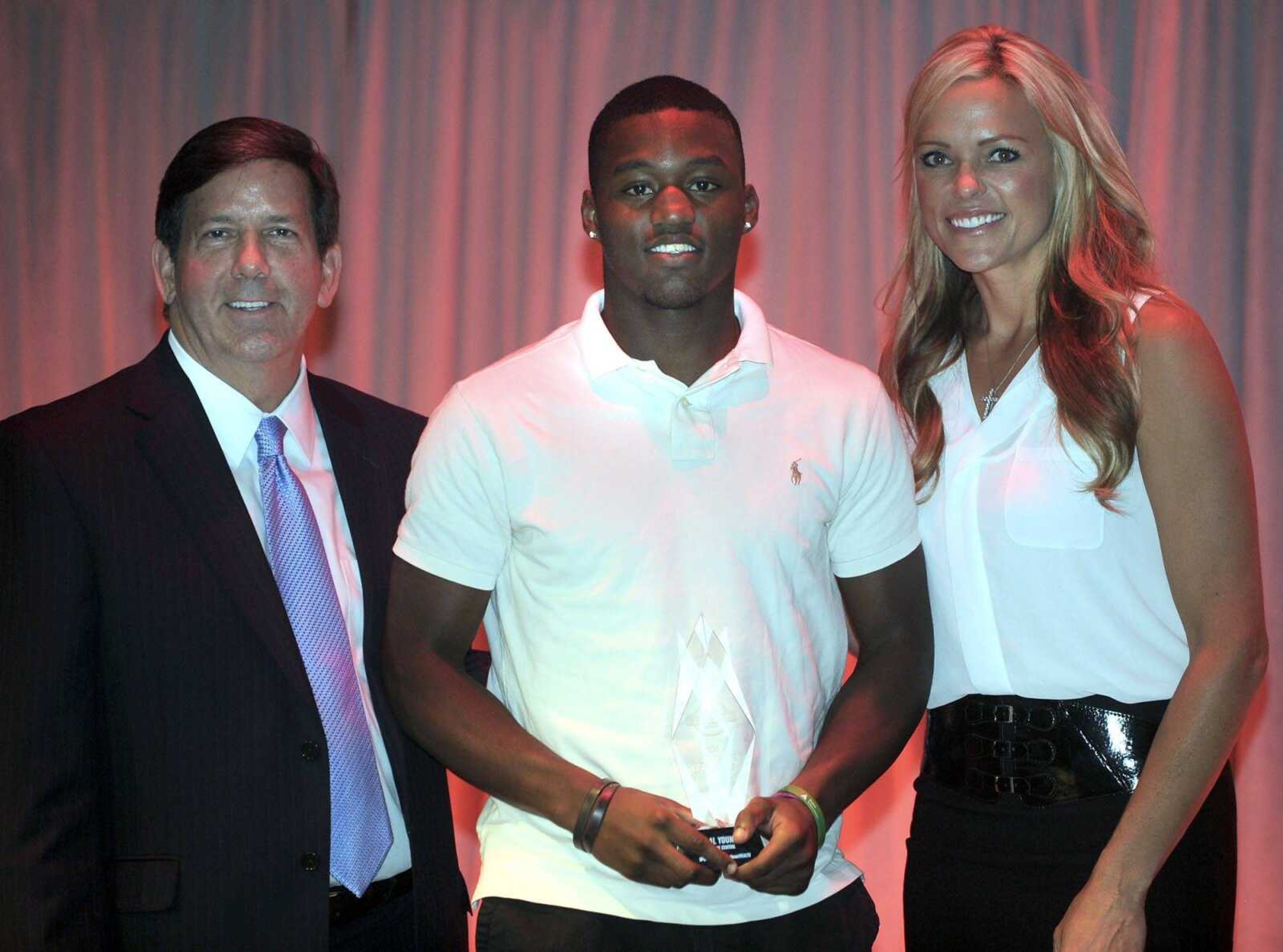 Cape Central's Al Young, center, receives the Male Athlete of the Year Award from Ken Bateman, left, president and CEO of SoutheastHEALTH, and Jennie Finch at the Semoball Awards Saturday, July 11, 2015 at the River Campus. (Fred Lynch)