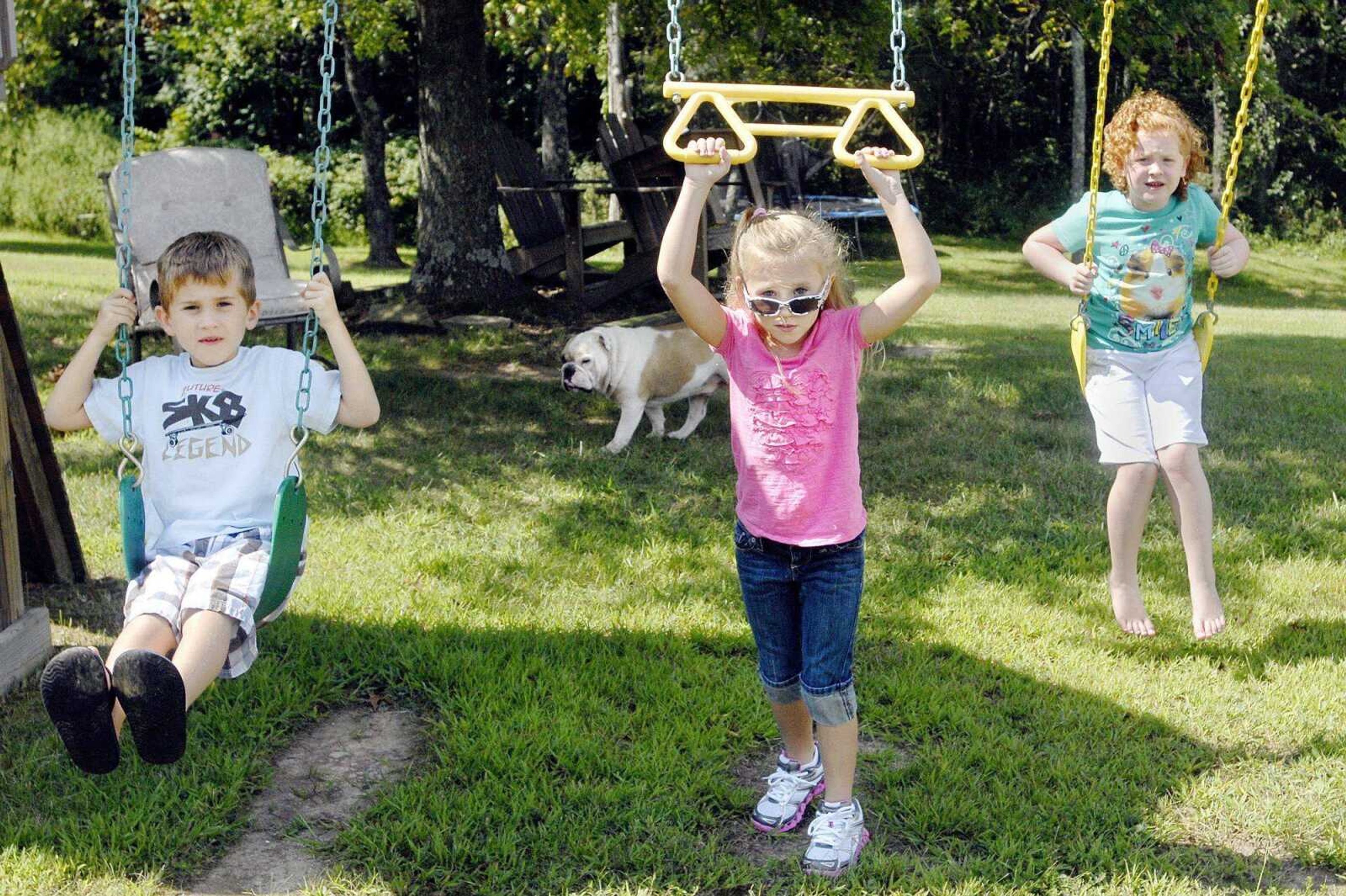 From left, Maddox, Avery and Addison Waller play on the swing set in their aunt Cheryl's backyard Tuesday in Farmington, Mo. The 5-year-old triplets have been living with their aunt since their mother, Jacque Sue Waller, disappeared June 1. (Laura Simon)