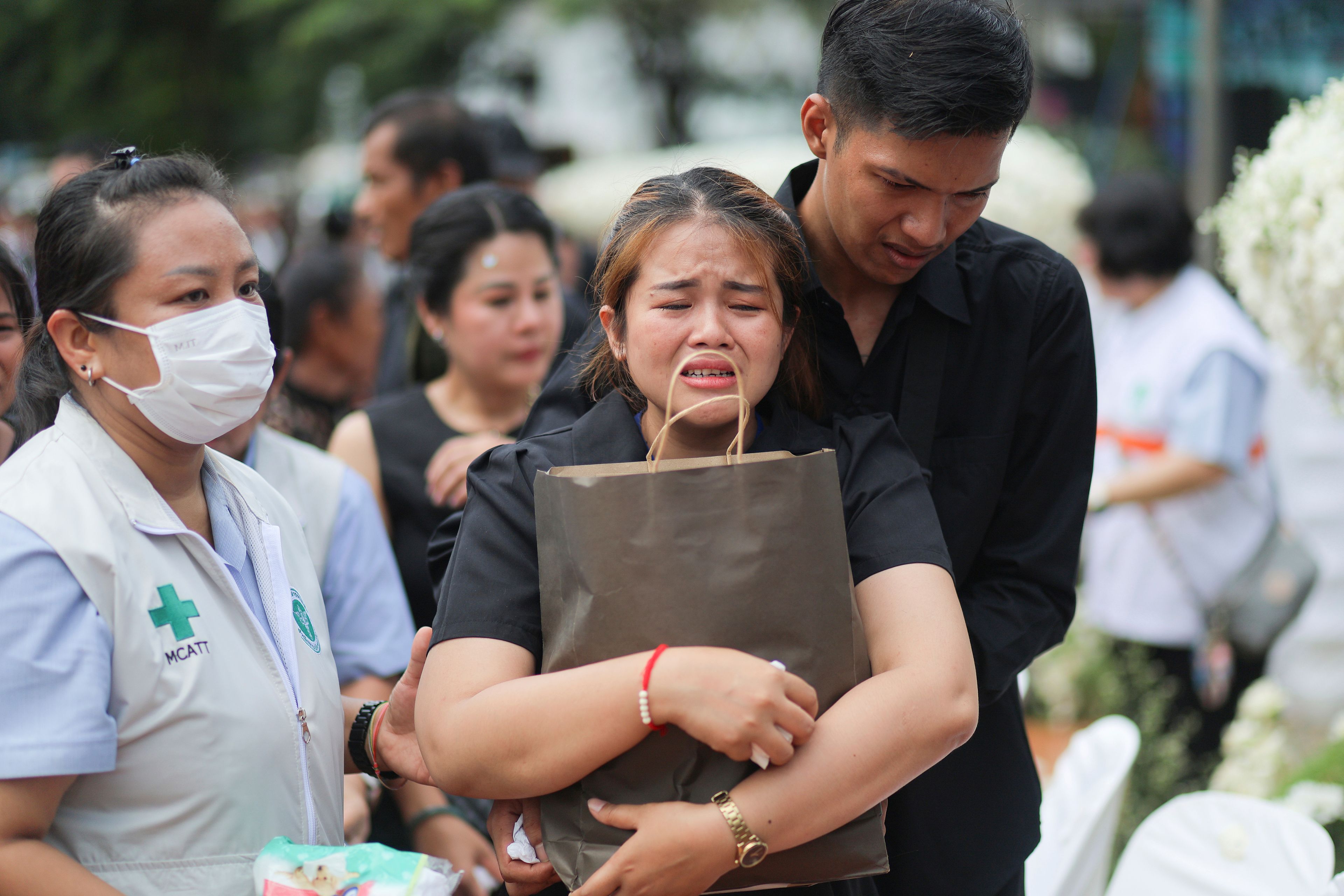 A family member mourns during the cremation ceremony for victims of a school bus fire, at Wat Khao Phraya Sangkharam School, Lan Sak, Uthai Thani province, Thailand, Tuesday, Oct. 8, 2024. (AP Photo/Chatkla Samnaingjam)