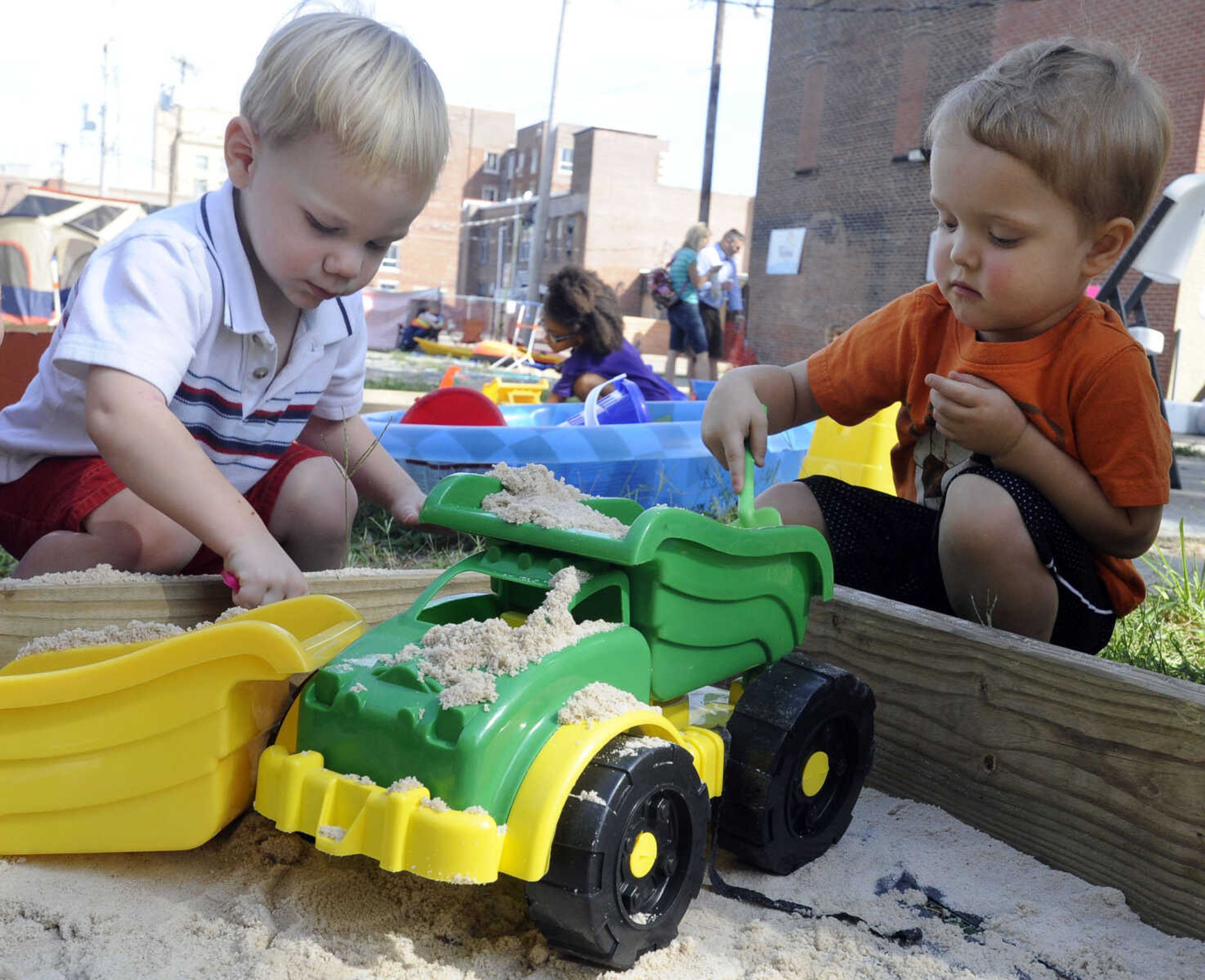 Marty Hoffman, left, and Peyton Neader play in a sandbox Sunday, Sept. 15, 2013 during the Celebration of Life event for Levi Collom at the Discovery Playhouse.