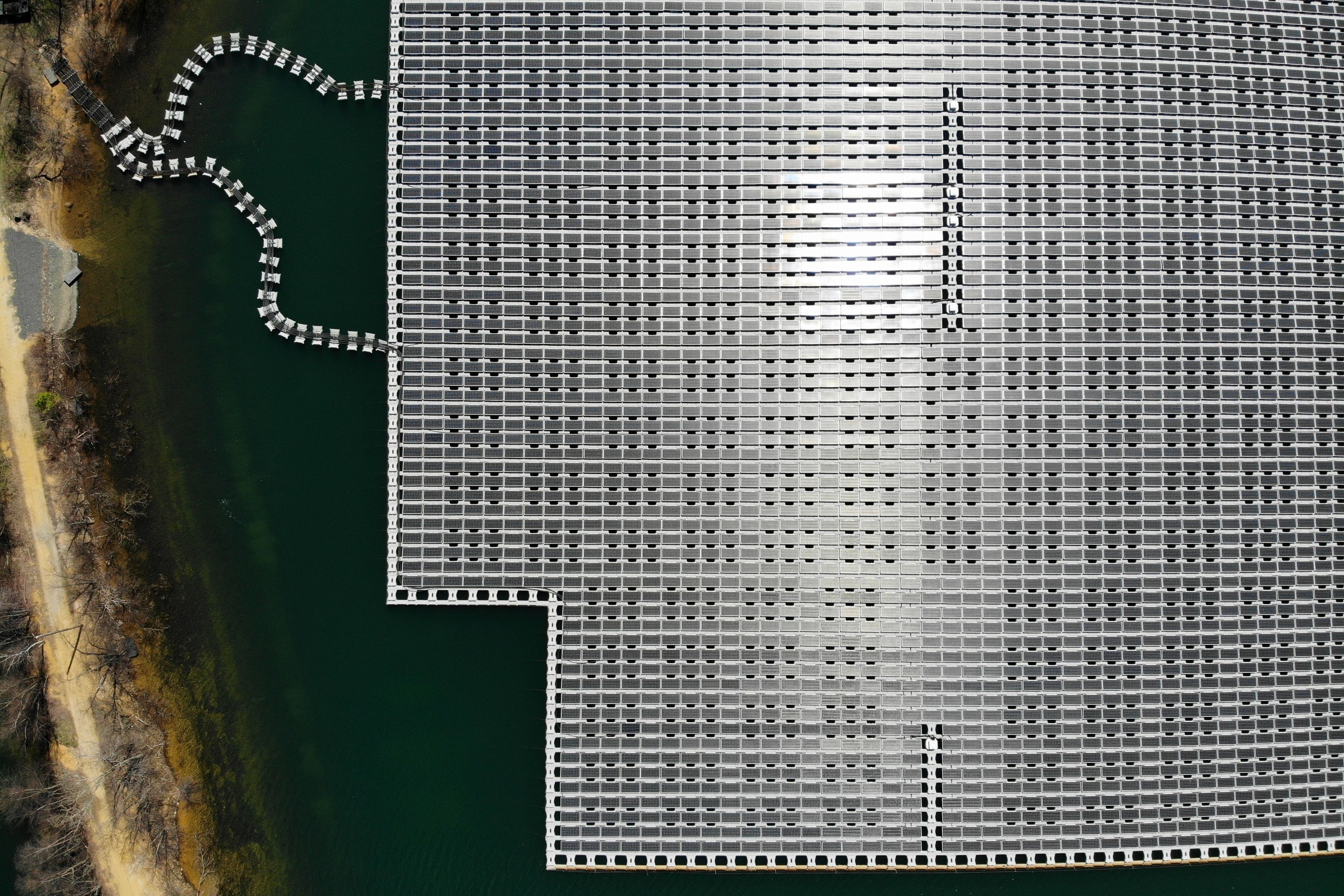 FILE - An array of solar panels float on top of a water storage pond in Sayreville, N.J., April 10, 2023. (AP Photo/Seth Wenig, File)