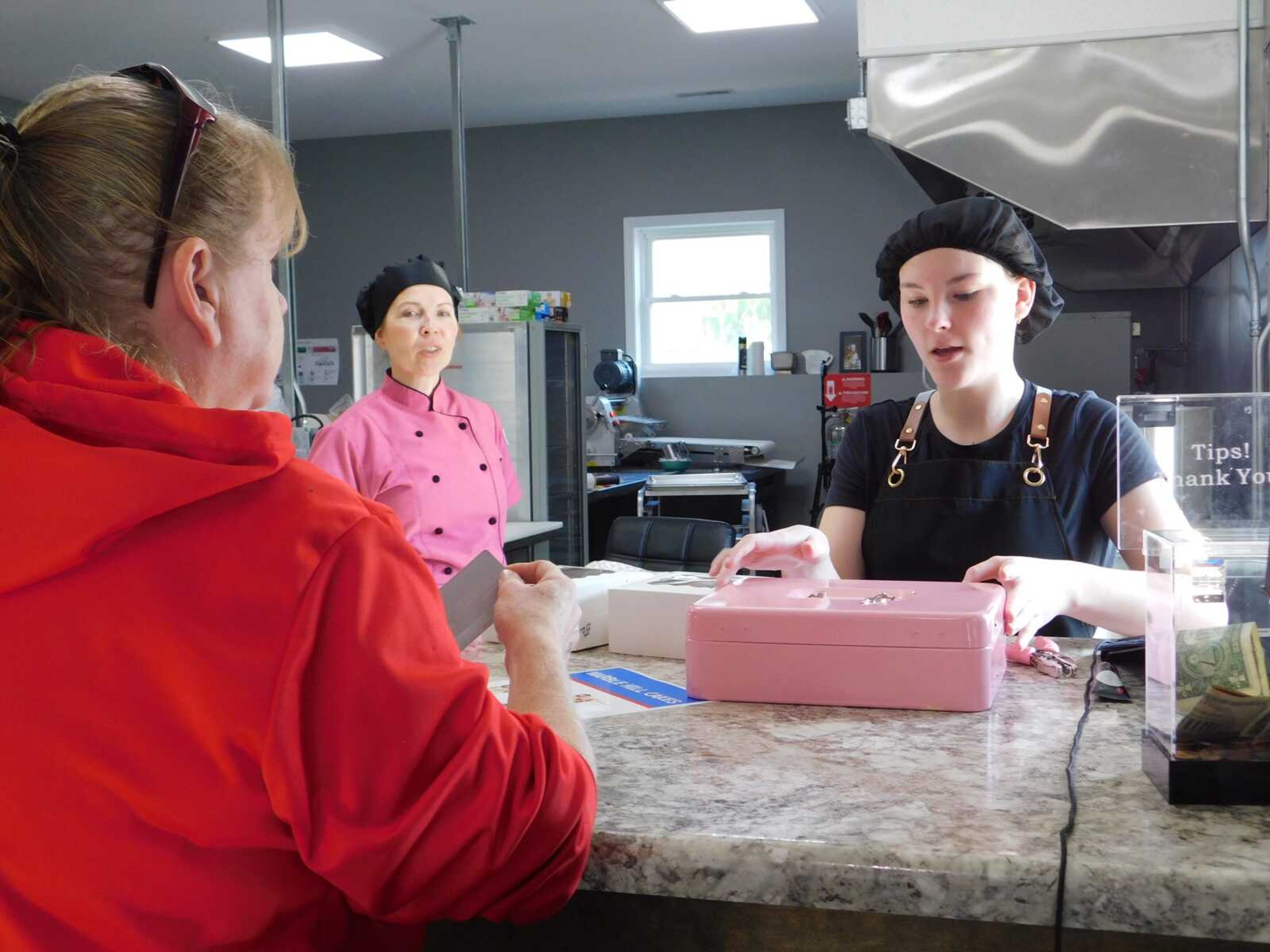 Kamryn Cook, right, hands customer Cindy Eckerle her order at Marble Hill Cakes on Thursday, Oct. 19, in Jackson. The bakery recently moved to its new location from Marble Hill.