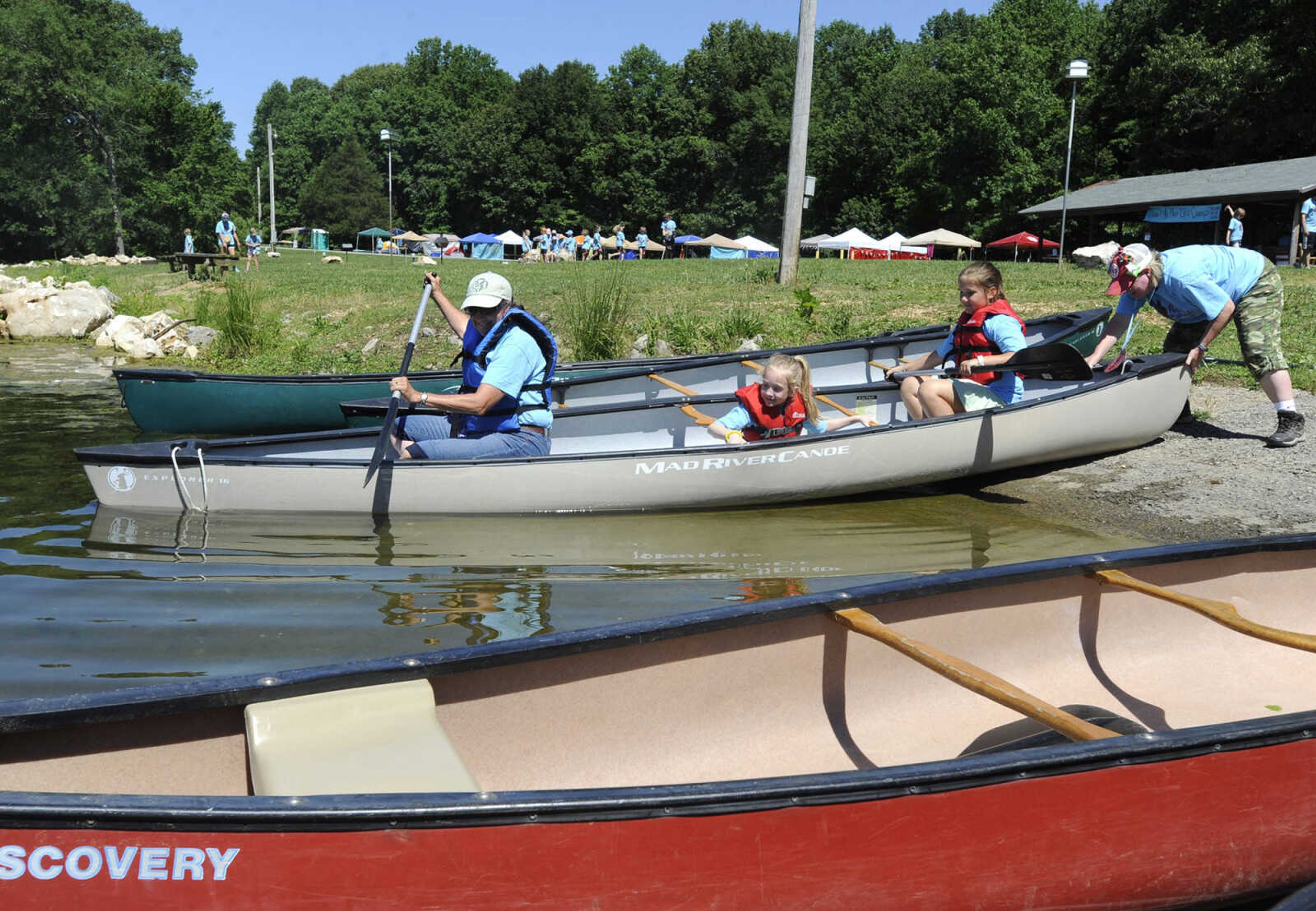 FRED LYNCH ~ flynch@semissourian.com
Brownie Girl Scouts Ciara Hall, center, and Aubrey Coher begin a canoe ride with volunteer Bonnie Coy-Svenson, left, as Laura Clubb helps launch the canoe Thursday, June 8, 2017 during Girl Scout day camp at Elks Lake in Cape Girardeau.