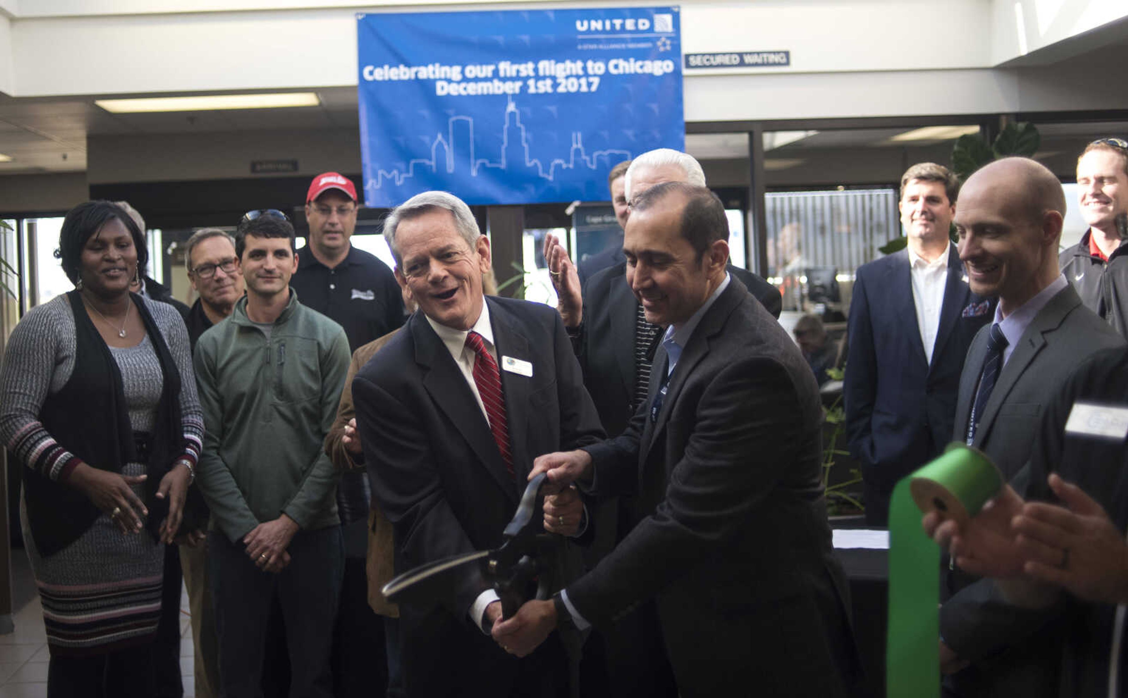 Airport manager Bruce Loy cuts the ribbon during the inaugural trip to Chicago on a CRJ200 airplane with SkyWest Friday, Dec. 1, 2017 at Cape Girardeau Regional Airport in Cape Girardeau.