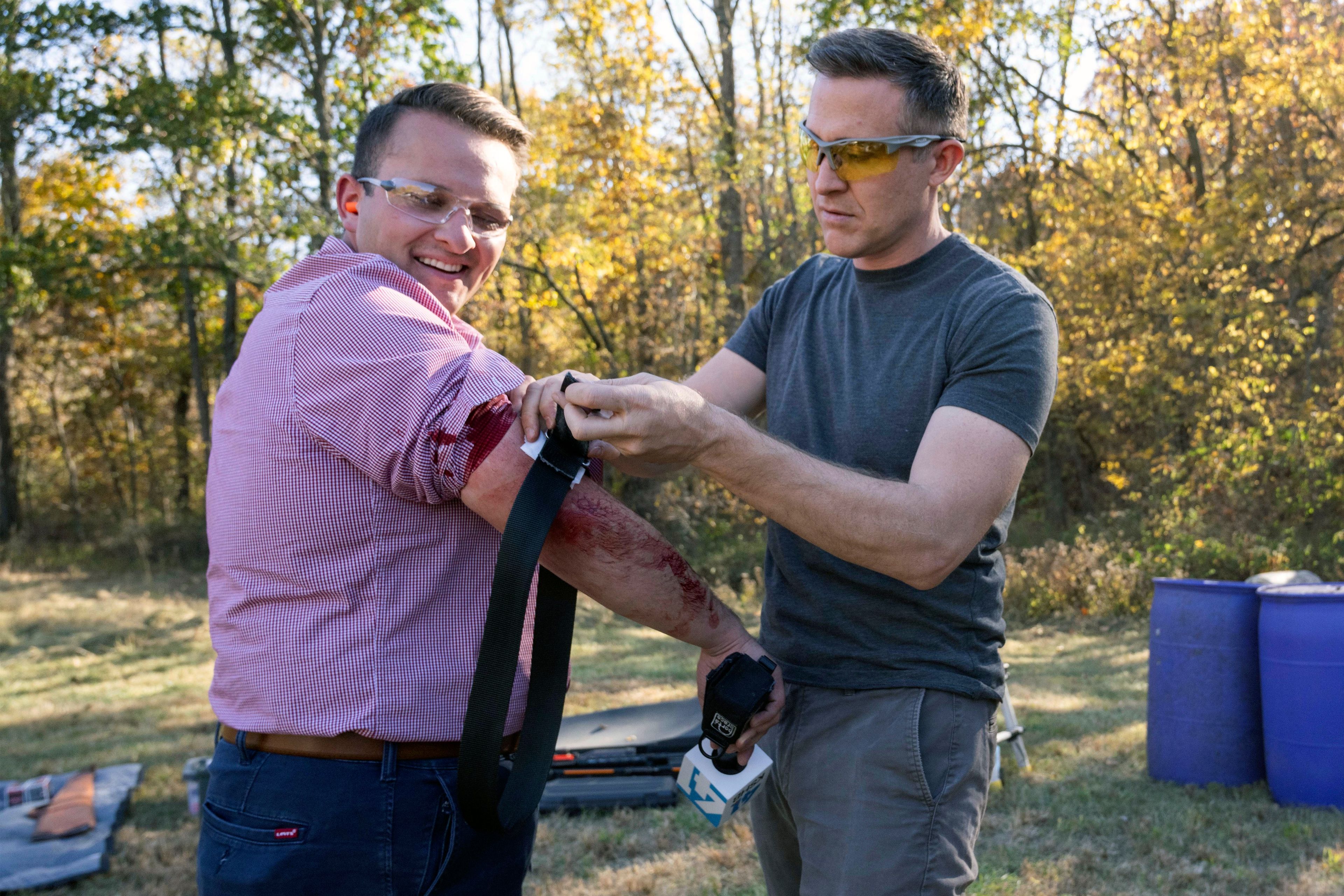 Democratic U.S. senate candidate Lucas Kunce, right, applies first aid to KSHB reporter Ryan Gamboa after Gamboa was struck by a metal fragment during a sport shooting campaign event Tuesday, Oct. 22, 2024 in Holt, Missouri. (Dominick Williams/The Kansas City Star via AP)