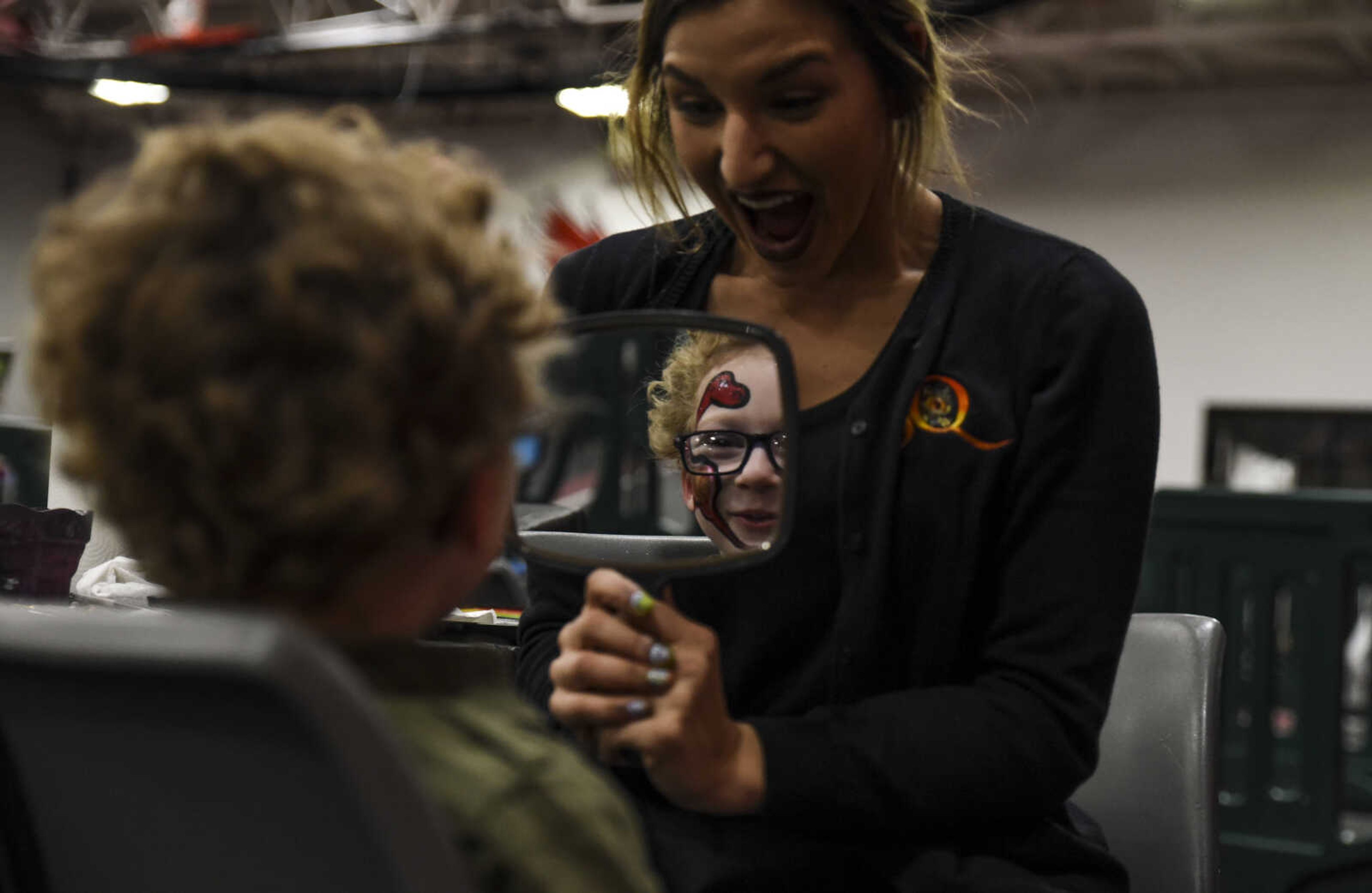 Rachel Szitas shows Keegan Mahaney, 5, his face paint at Jurassic Quest Friday, April 27, 2018, at the Show Me Center in Cape Girardeau.