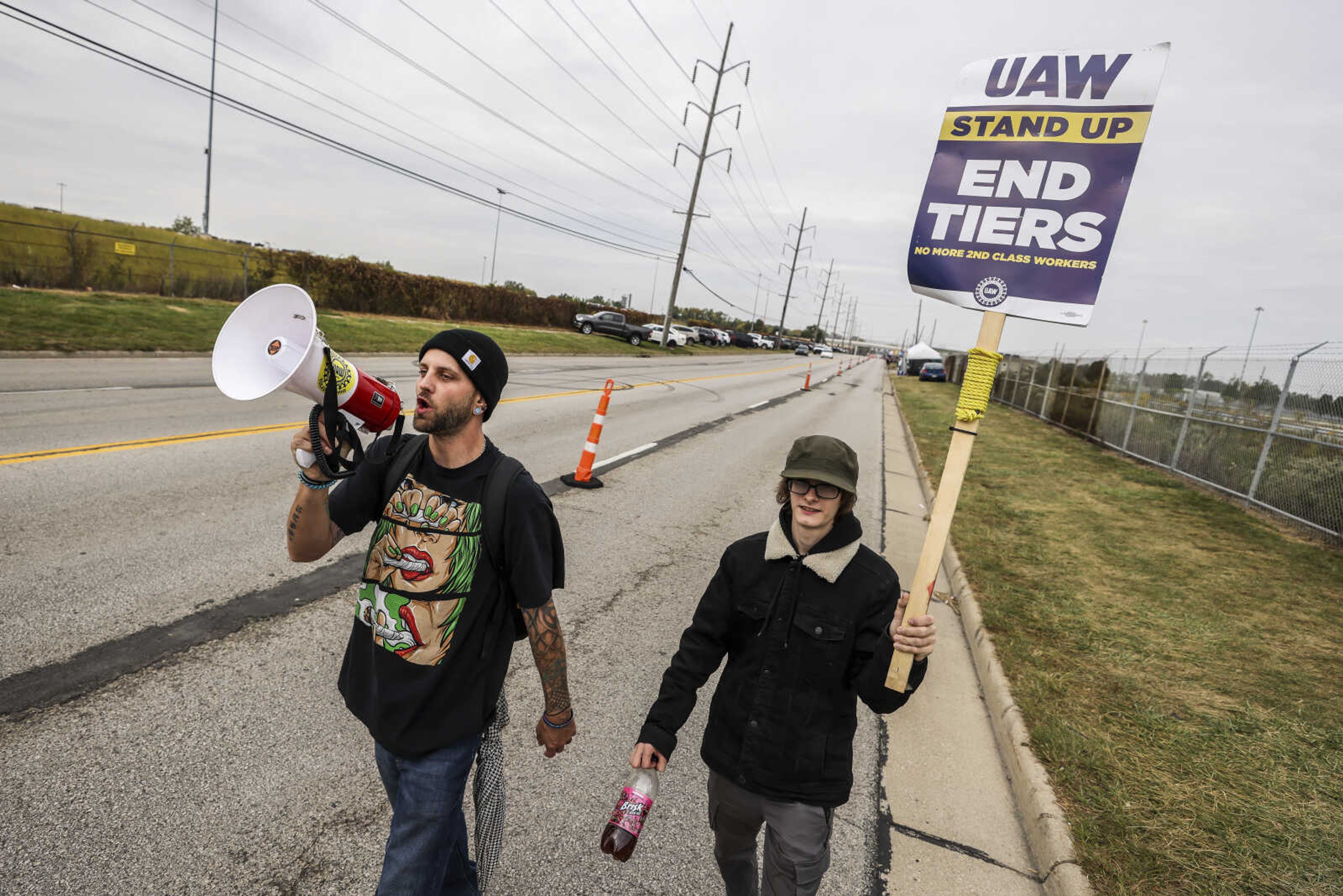 United Auto Workers members Josh Rainey of Team 60, left, and Josh McVicker of Team 83 picket outside a gate at Stellantis Toledo Assembly Complex on Thursday, Oct. 12, 2023 in Toledo, Ohio. (Isaac Ritchey/The Blade via AP)