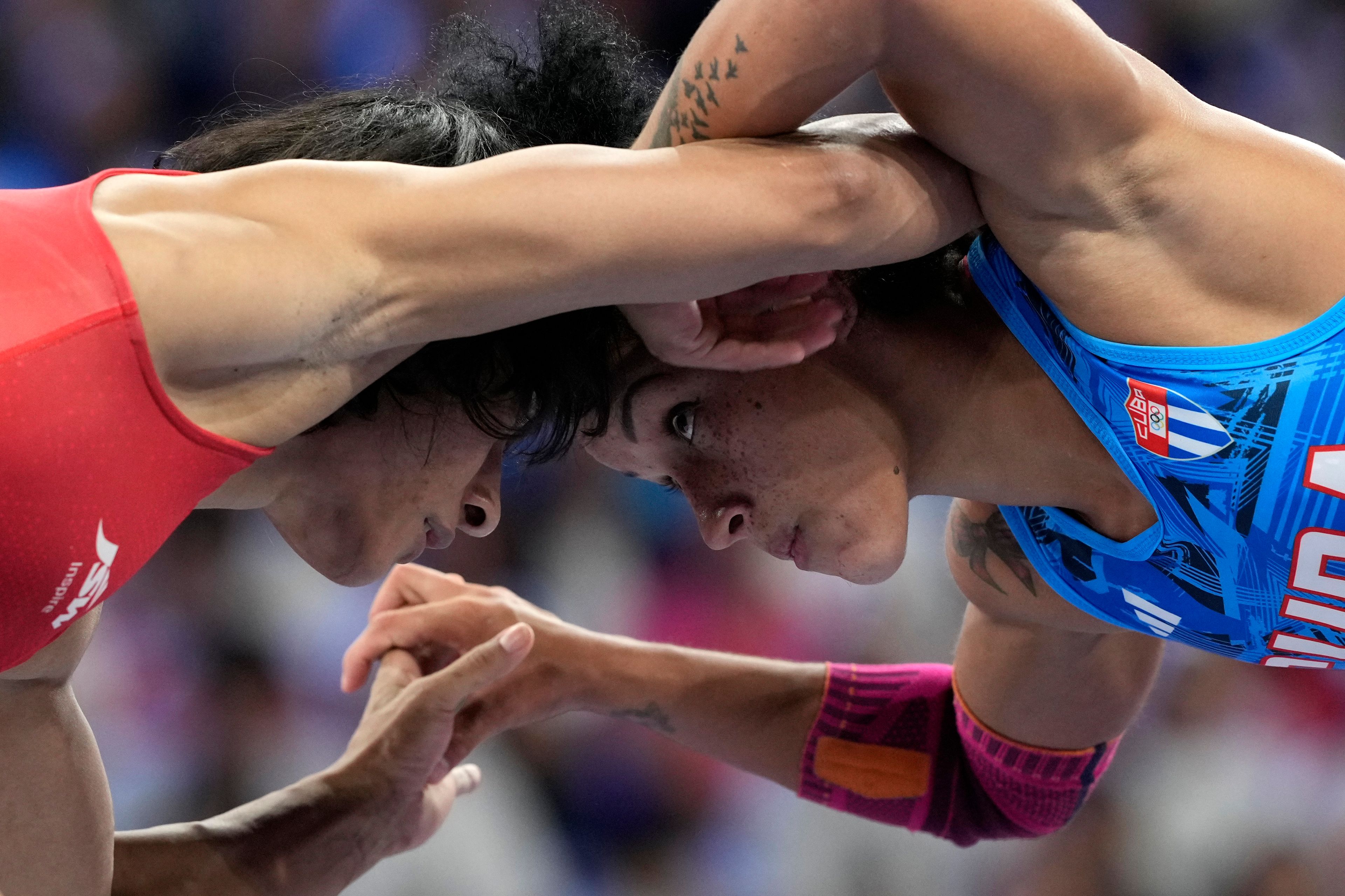 India's Vinesh Vinesh and Cuba's Yusneylys Guzman, right, compete during their women's freestyle 50kg wrestling semifinal match, at Champ-de-Mars Arena, during the 2024 Summer Olympics, Tuesday, Aug. 6, 2024, in Paris, France. (AP Photo/Eugene Hoshiko)