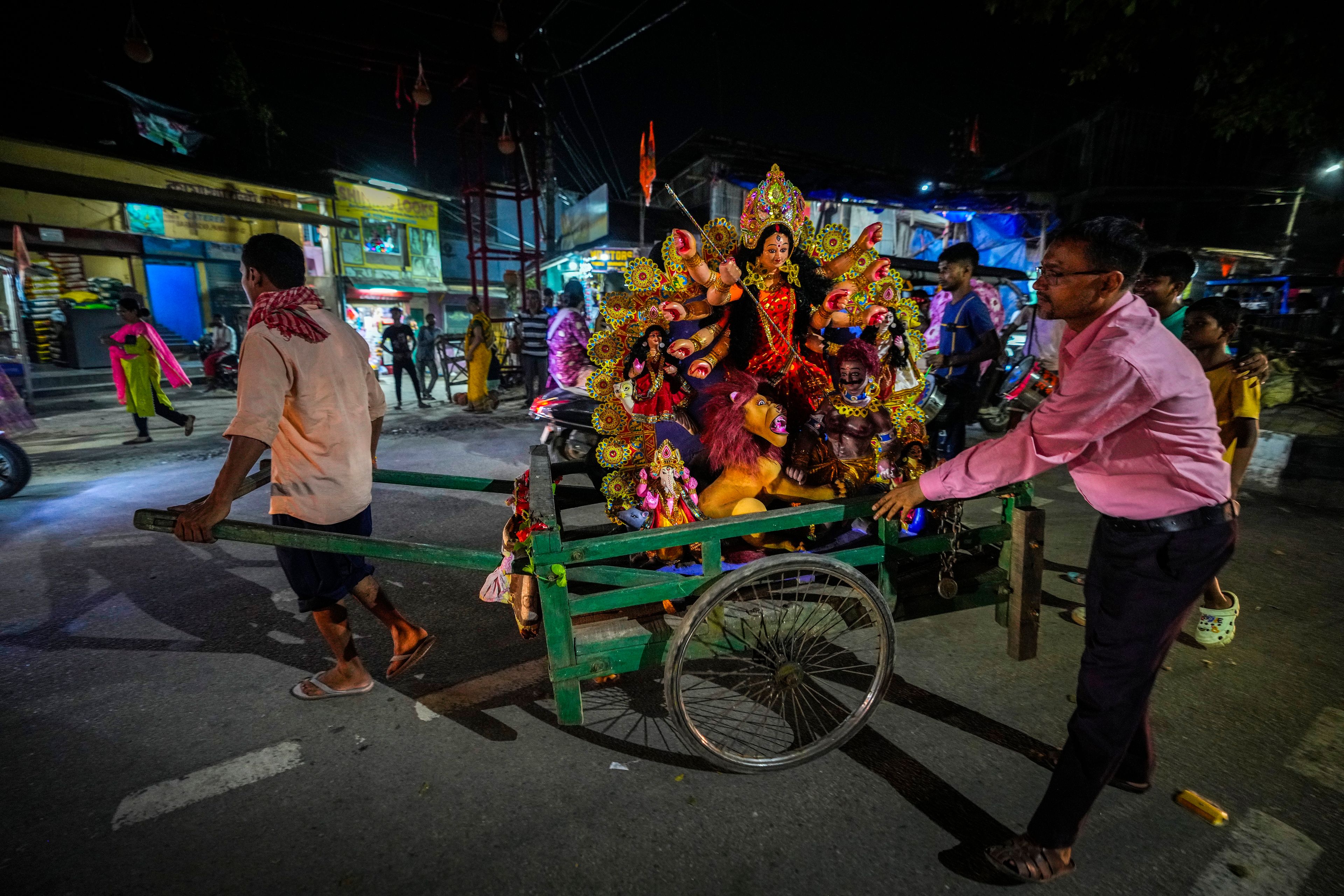 A customer transports a mud idol of the Hindu goddess Durga on a pushcart after collecting it from a workshop during the Durga Puja festival in Guwahati, India, Tuesday, Oct. 8, 2024. (AP Photo/Anupam Nath)