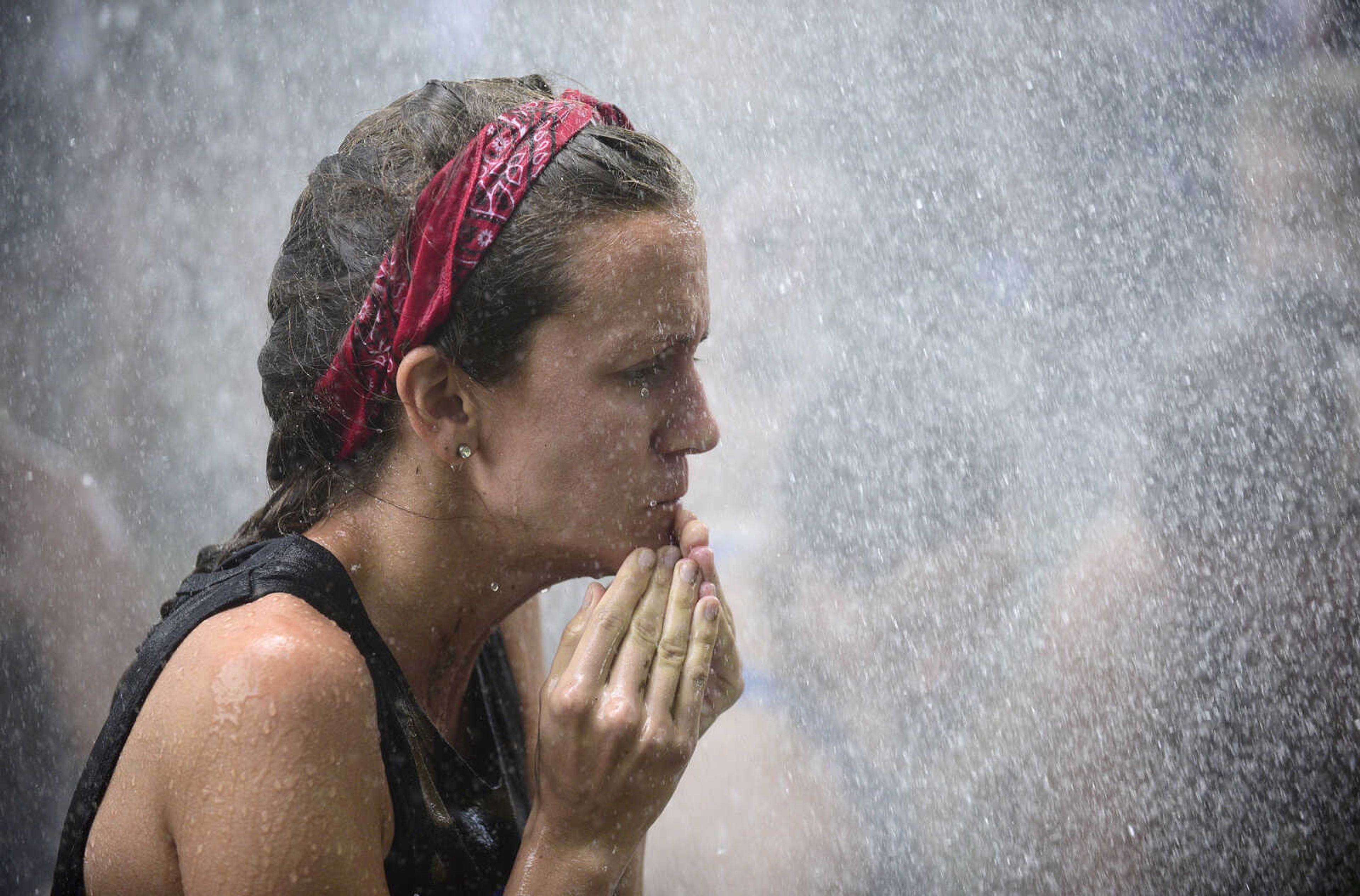 Team members hit the wash station after playing mud volleyball during the Fourth of July celebration on Tuesday at Jackson City Park.