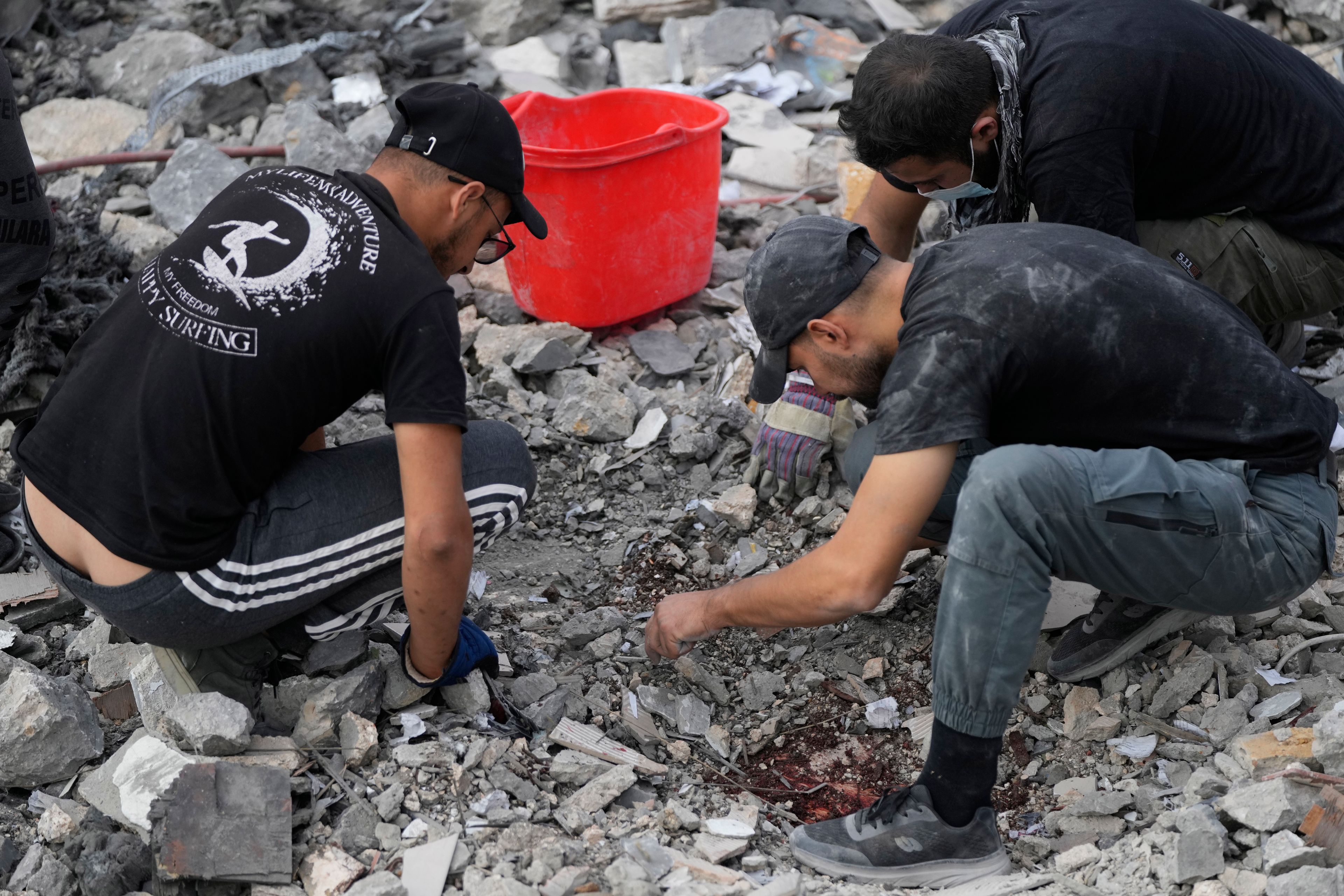 Rescue workers search for victims under the rubble of a destroyed house hit in an Israeli airstrike, in Aalmat village, northern Lebanon, Sunday, Nov. 10, 2024. (AP Photo/Hassan Ammar)