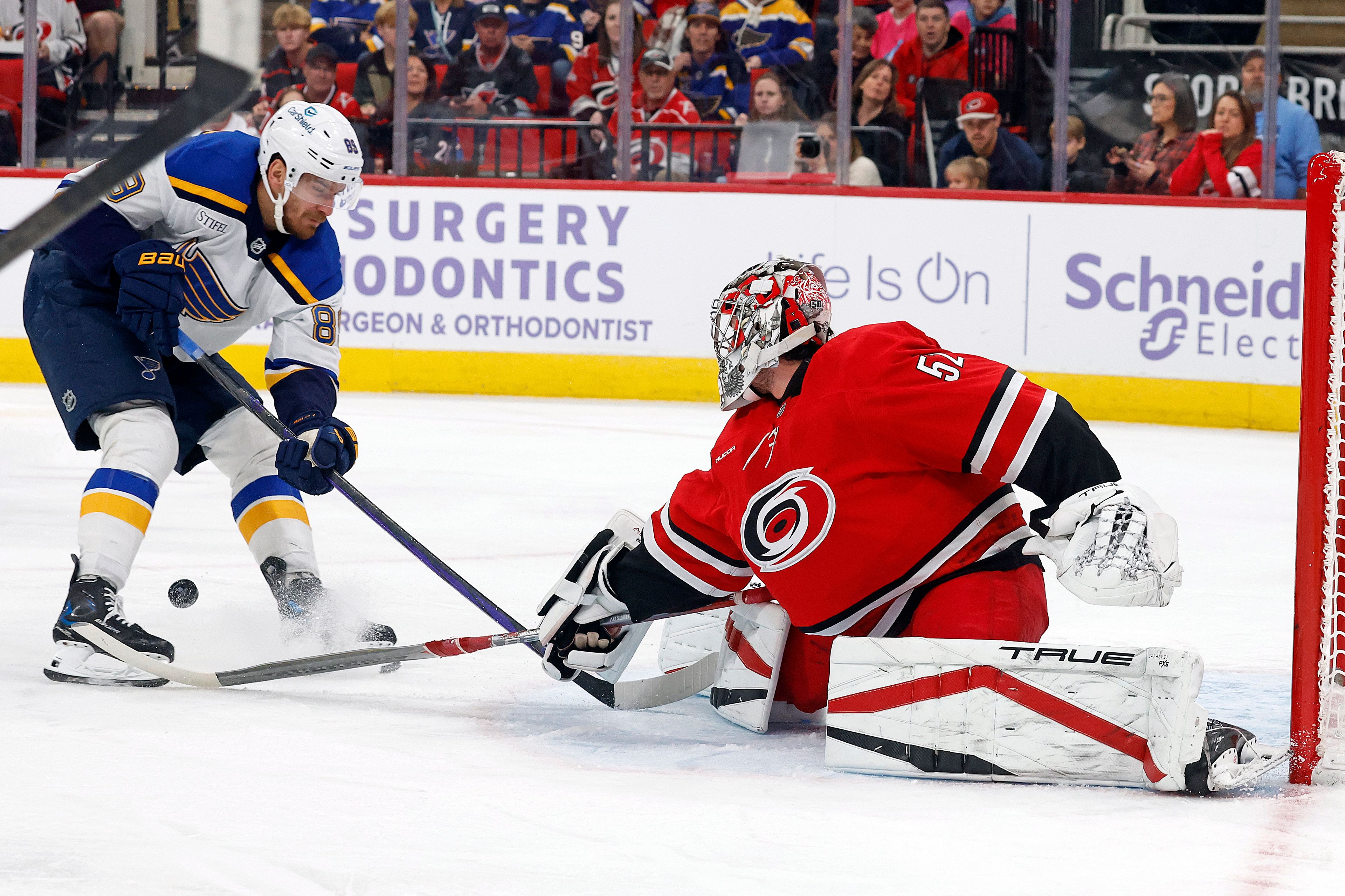 Carolina Hurricanes goaltender Pyotr Kochetkov (52) poke checks the puck away from St. Louis Blues' Pavel Buchnevich (89) during the first period of an NHL hockey game in Raleigh, N.C., Sunday, Nov. 17, 2024. (AP Photo/Karl B DeBlaker)