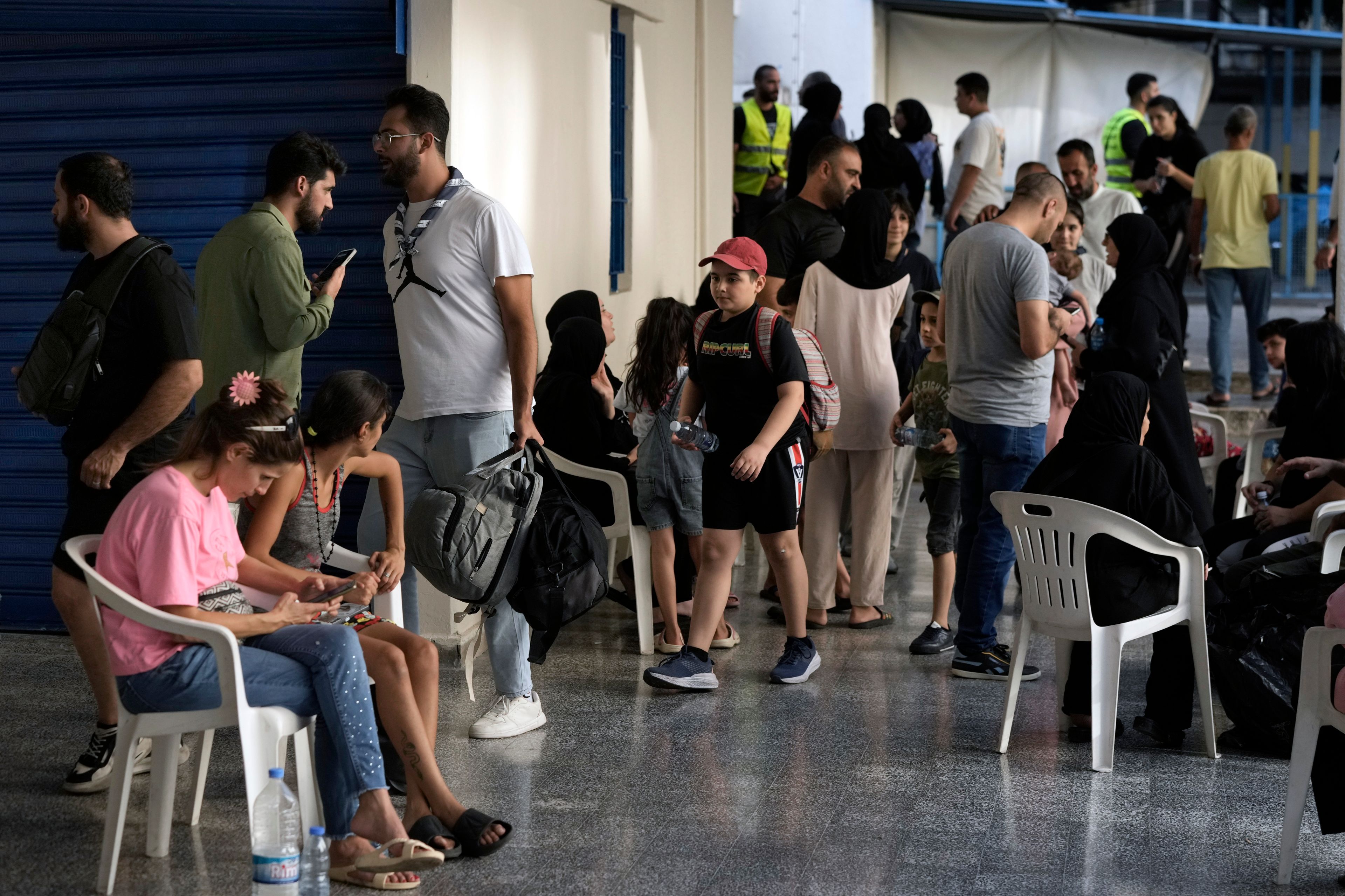 People fleeing the Israeli airstrikes in the south, arrive at a school turned into a shelter in Beirut, Monday, Sept. 23, 2024. (AP Photo/Bilal Hussein)