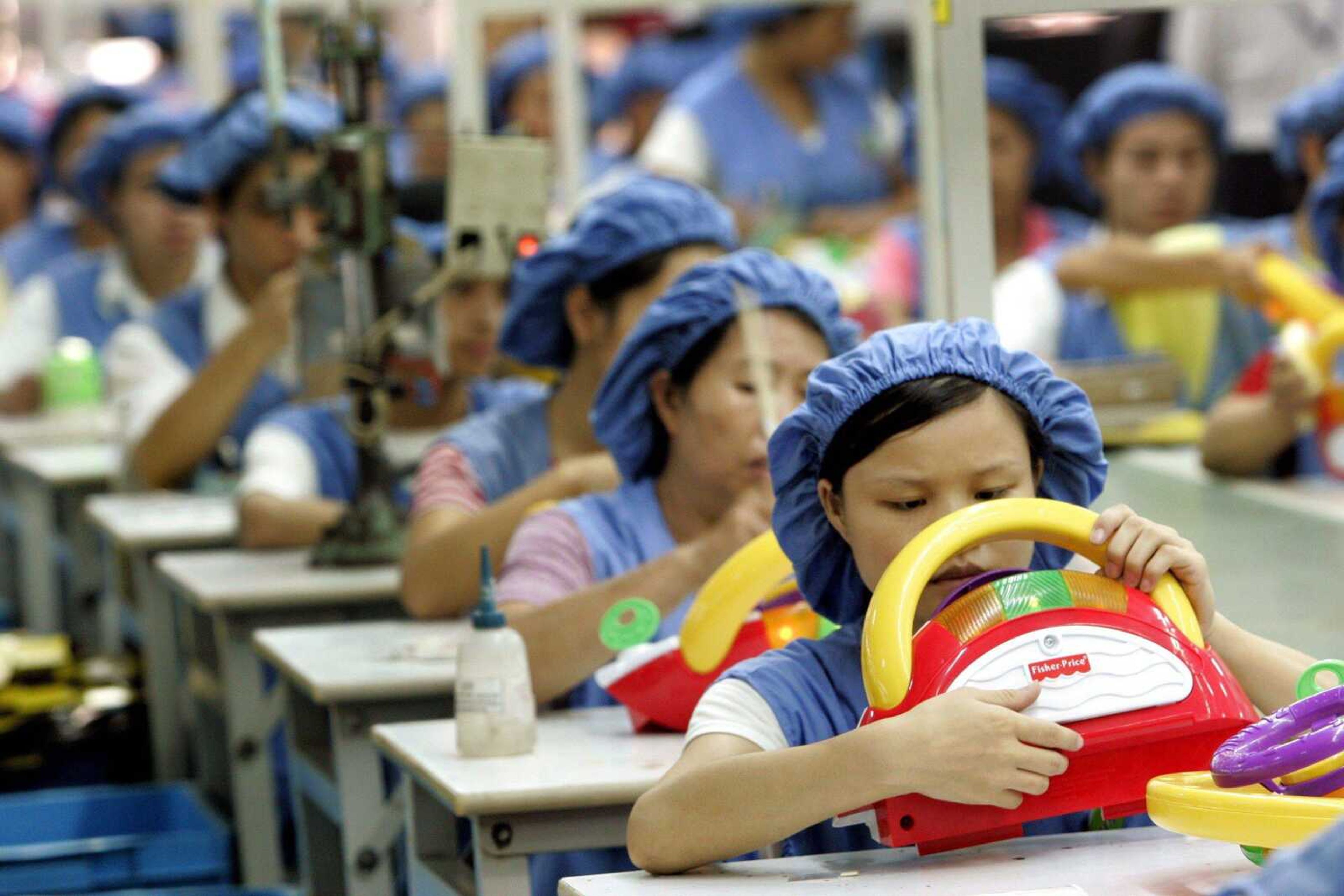 Workers assembled toy cars on the production line at Dongguan Da Lang Wealthwise Plastic Factory in Dongguan, China. (Eugene Hoshiko ~ Associated Press)