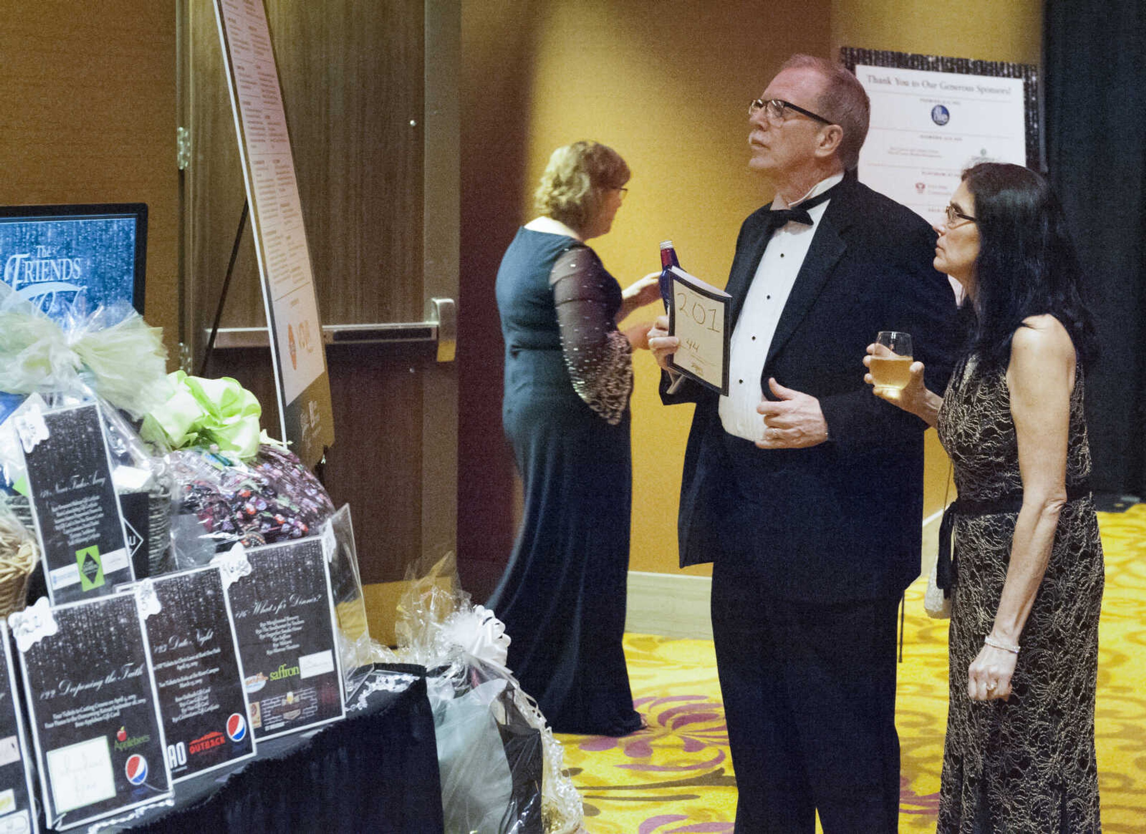 Jim and Cheryl Lawrence of Cape Girardeau look at auction items before The Friends Gala on Saturday at Isle Casino Cape Girardeau.