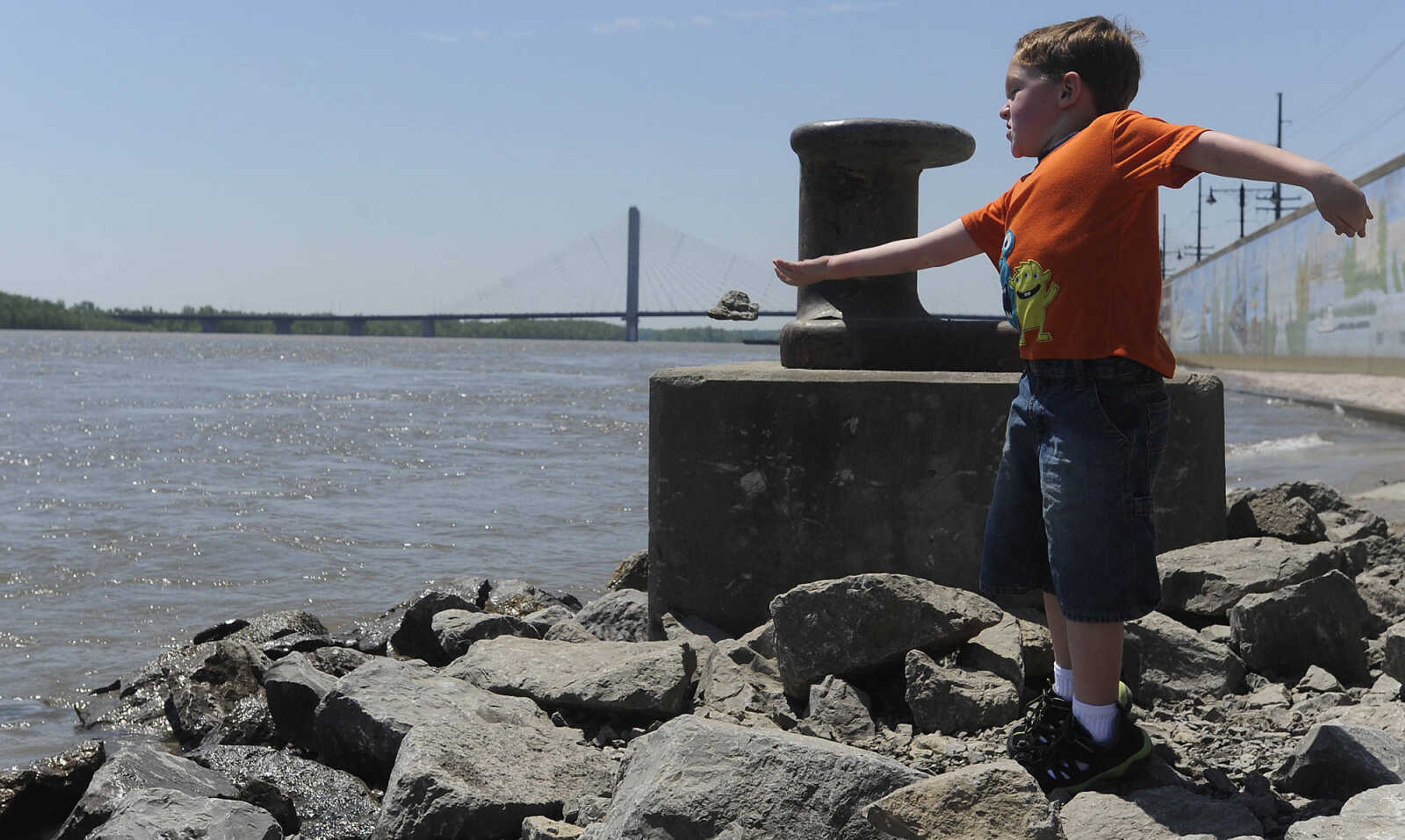 Colin Vickory, 5, throws a rock into the Mississippi River at Riverfront Park Wednesday, May 15, in Cape Girardeau. The Broadway floodgate has been opened but the floodgate at Themis Street remains closed.