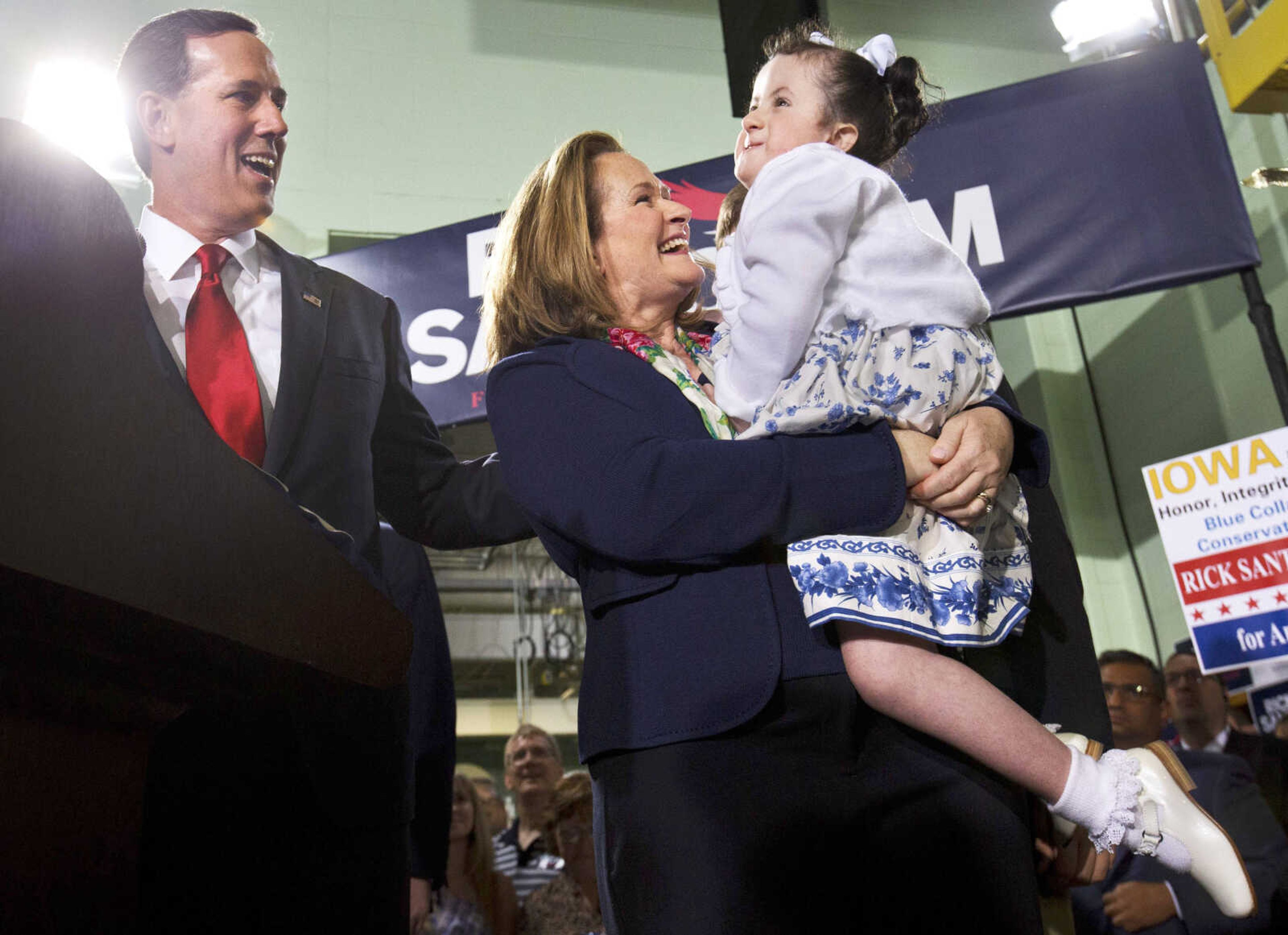 Former Pennsylvania senator Rick Santorum, left, smiles at his daughter Bella, who has trisomy 18, held by his wife, Karen, during his announcement he is entering the Republican presidential race, May 27, 2015, in Cabot, Pennsylvania.