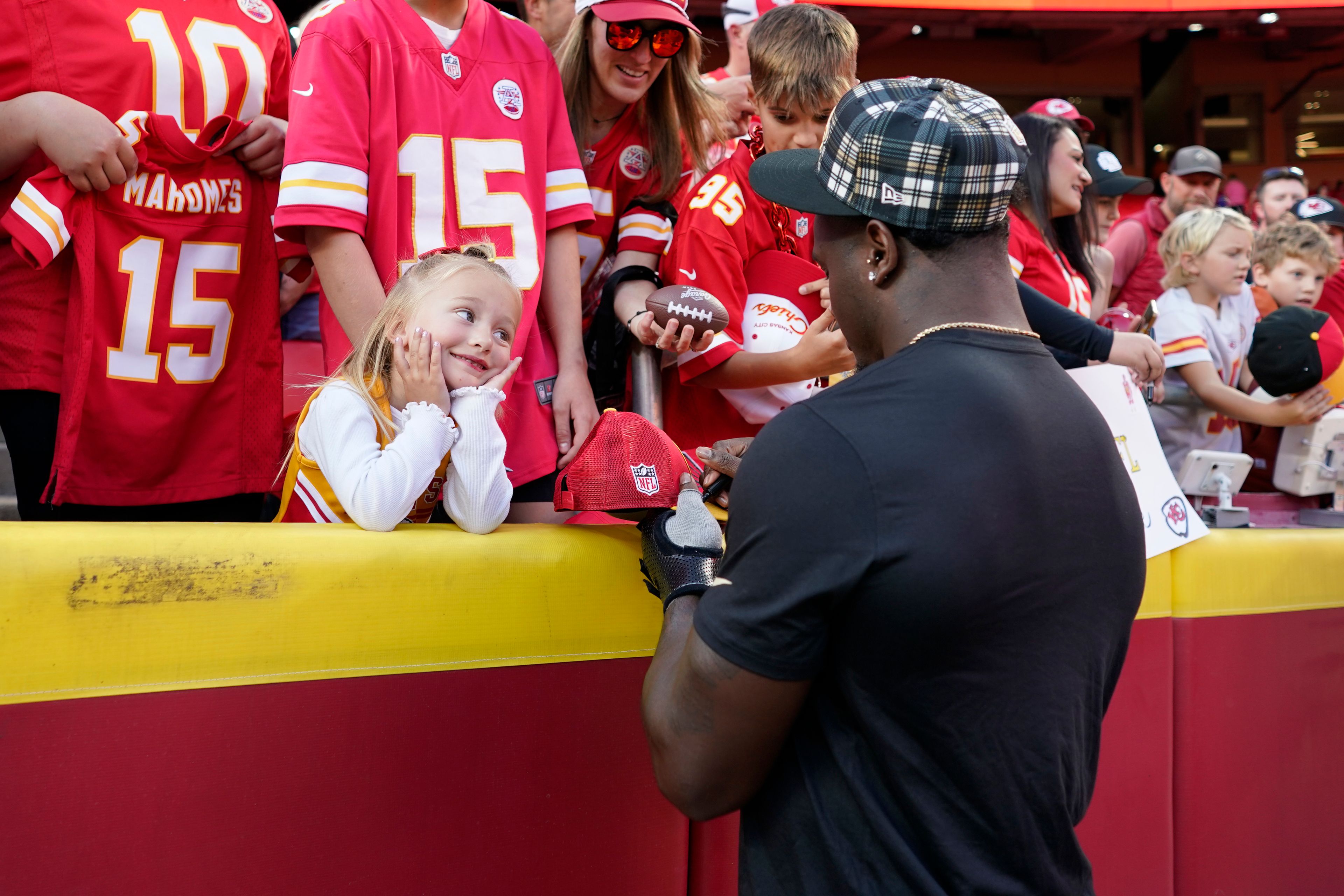 New Orleans Saints linebacker Willie Gay Jr. signs autographs for a young fan before the start of an NFL football game against the Kansas City Chiefs Monday, Oct. 7, 2024, in Kansas City, Mo. (AP Photo/Ed Zurga)