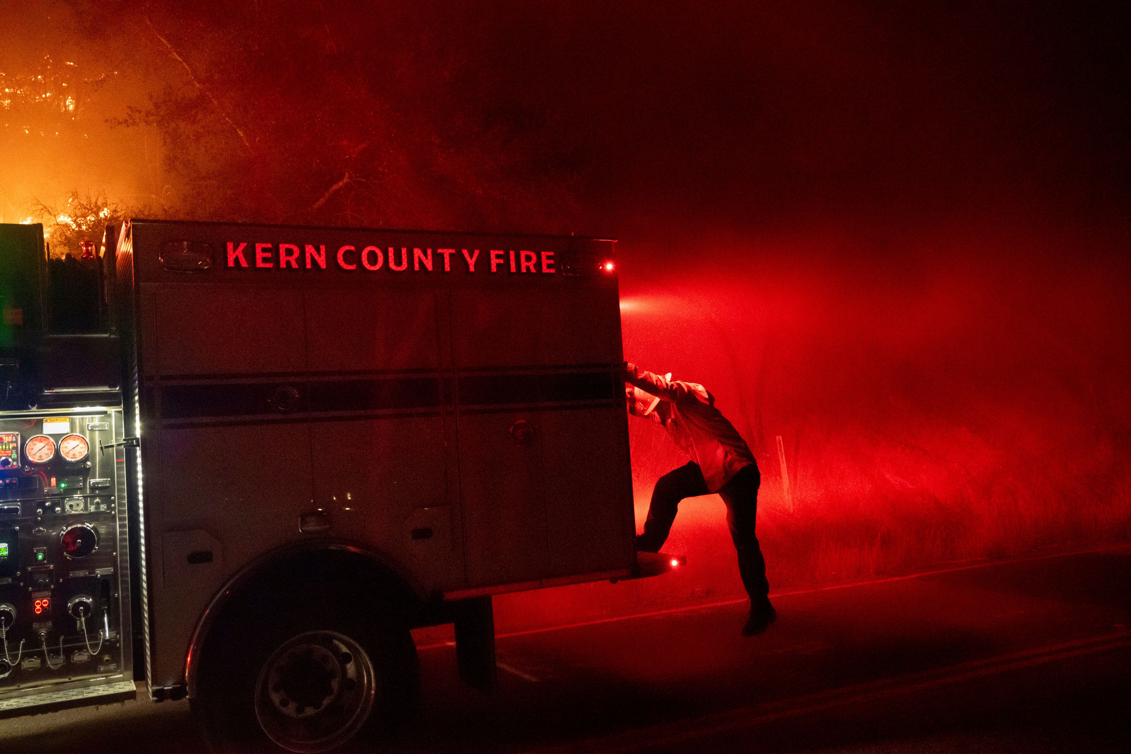 A firefighter climbs off an engine while battling the Mountain Fire on Wednesday, Nov. 6, 2024, in Santa Paula, Calif. (AP Photo/Noah Berger)