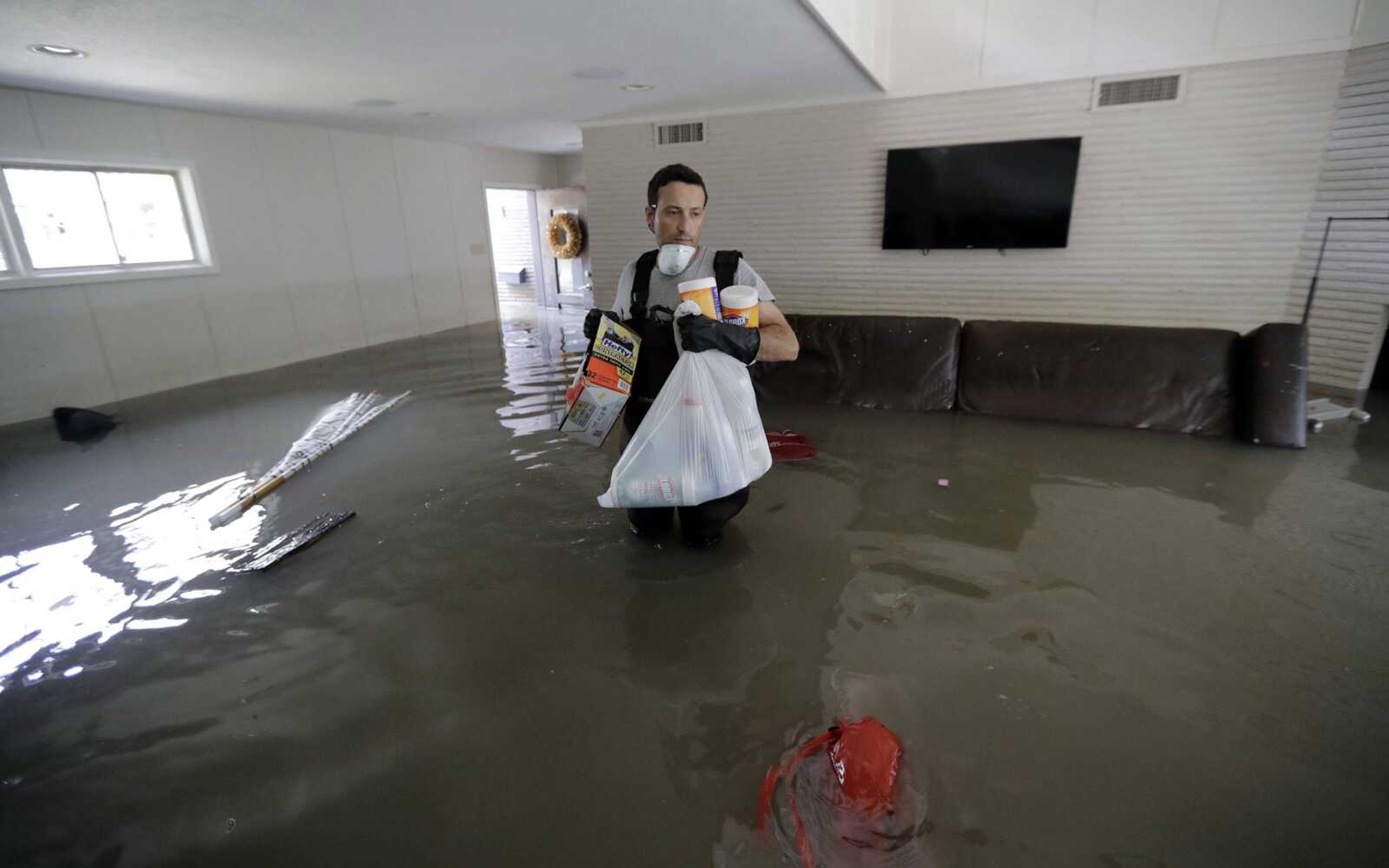 Gaston Kirby walks through floodwater inside his home Monday in the aftermath of Harvey near the Addicks and Barker reservoirs in Houston.