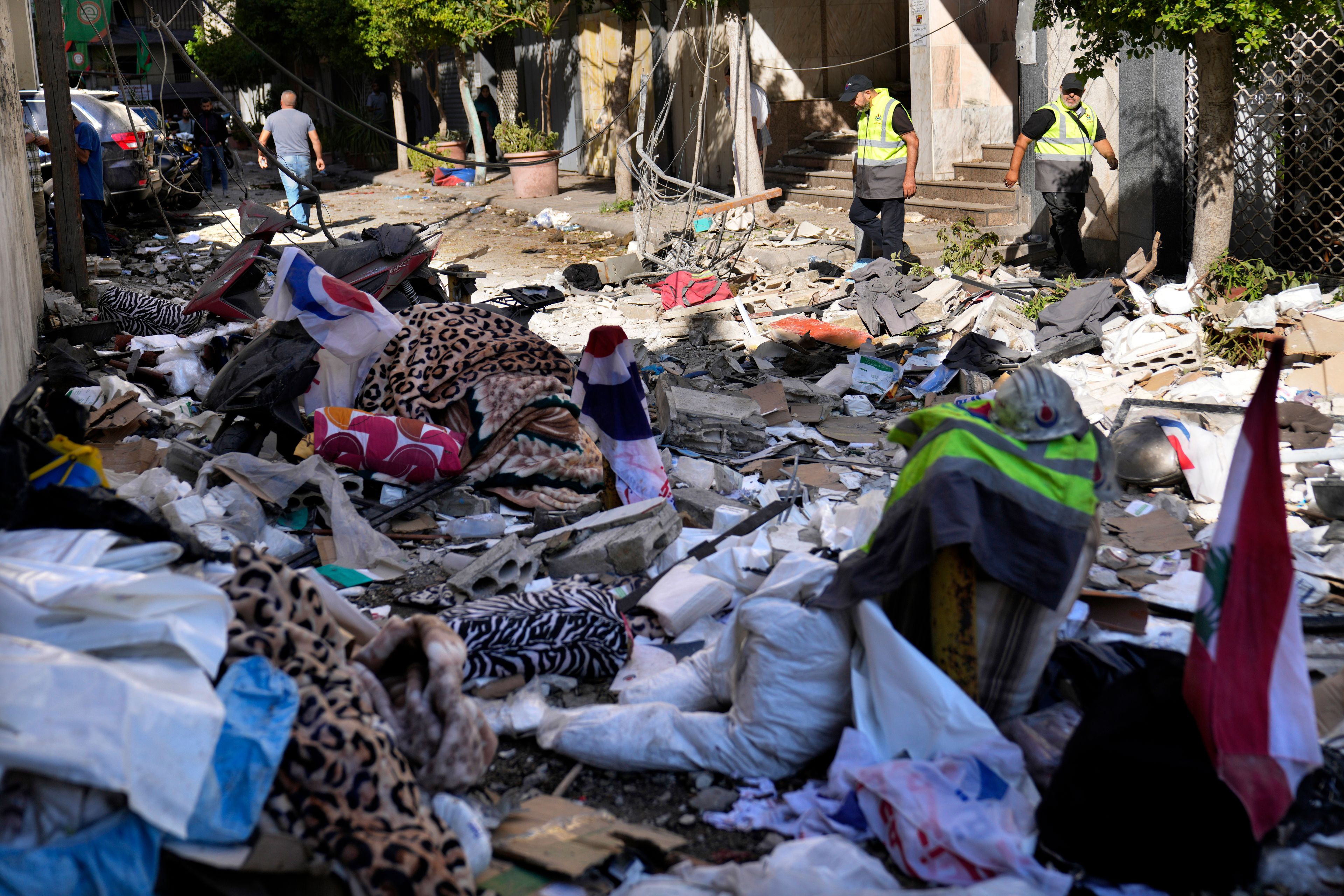 Hezbollah paramedics walk between debris after an airstrike hit an apartment in a multistory building, in central Beirut, Lebanon, Thursday, Oct. 3, 2024. (AP Photo/Hussein Malla)