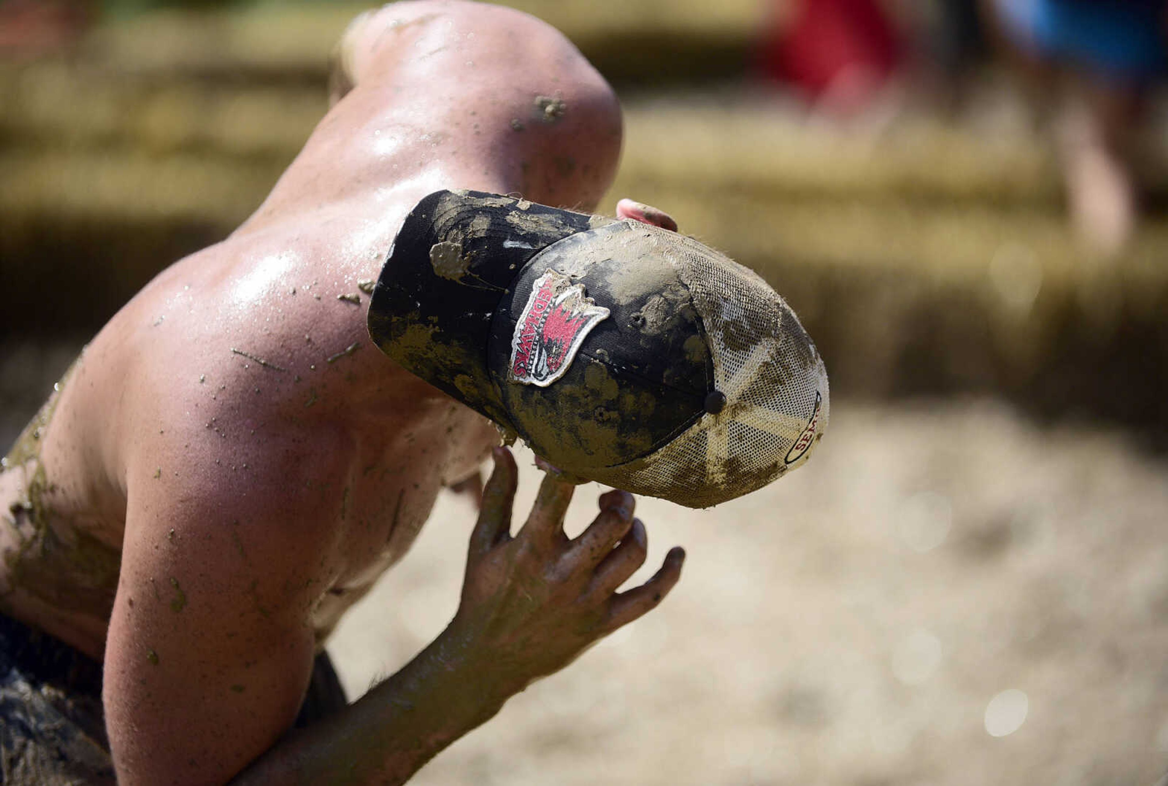 A player tries to get mud out of his ear during mud volleyball at the Fourth of July celebration on Tuesday at Jackson City Park.