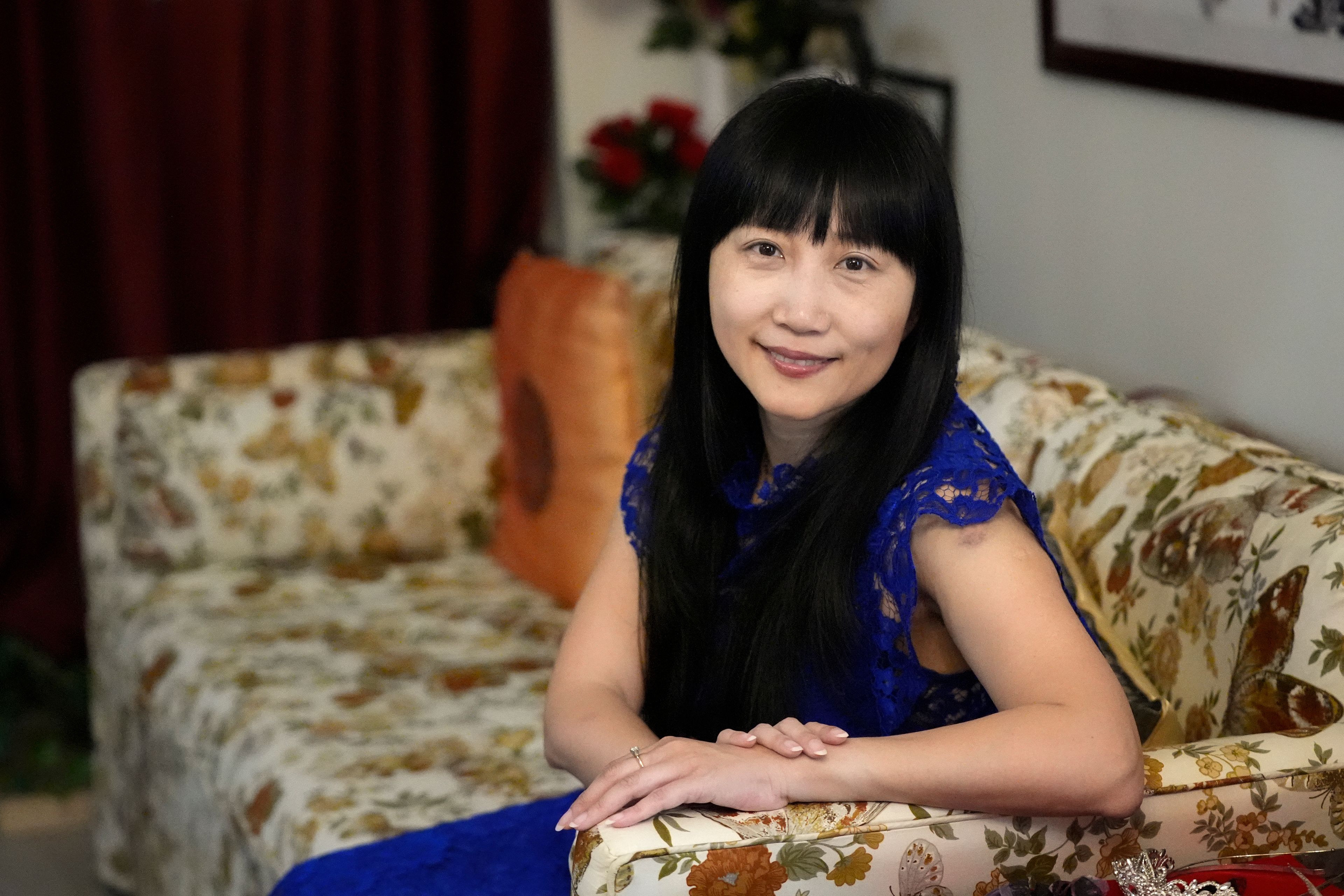 Diana Xue poses for a photo at her home Monday, Oct. 21, 2024, in Orlando, Fla. Xue is a naturalized U.S. citizen born in China who used to vote more Republican but has changed her mind after Florida passed the alien land law. (AP Photo/John Raoux)