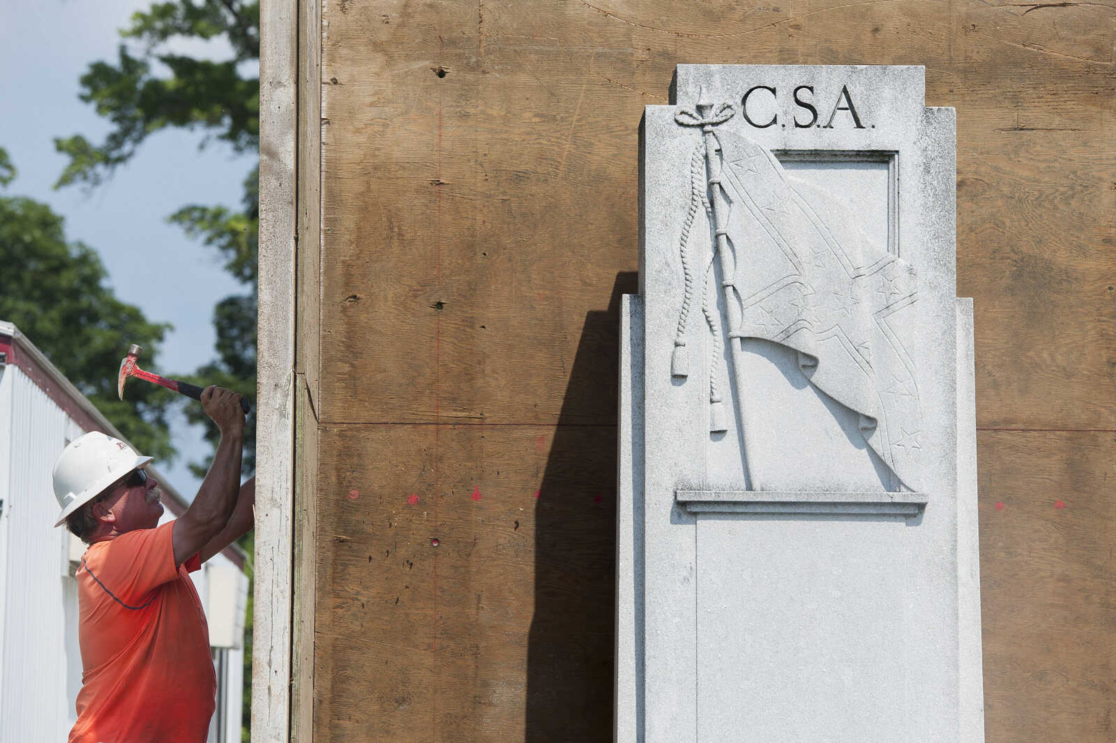 Construction workers nail together sides of a wooden box surrounding a Confederate States of America monument in Ivers Square on Tuesday, July 7, 2020, in Cape Girardeau.