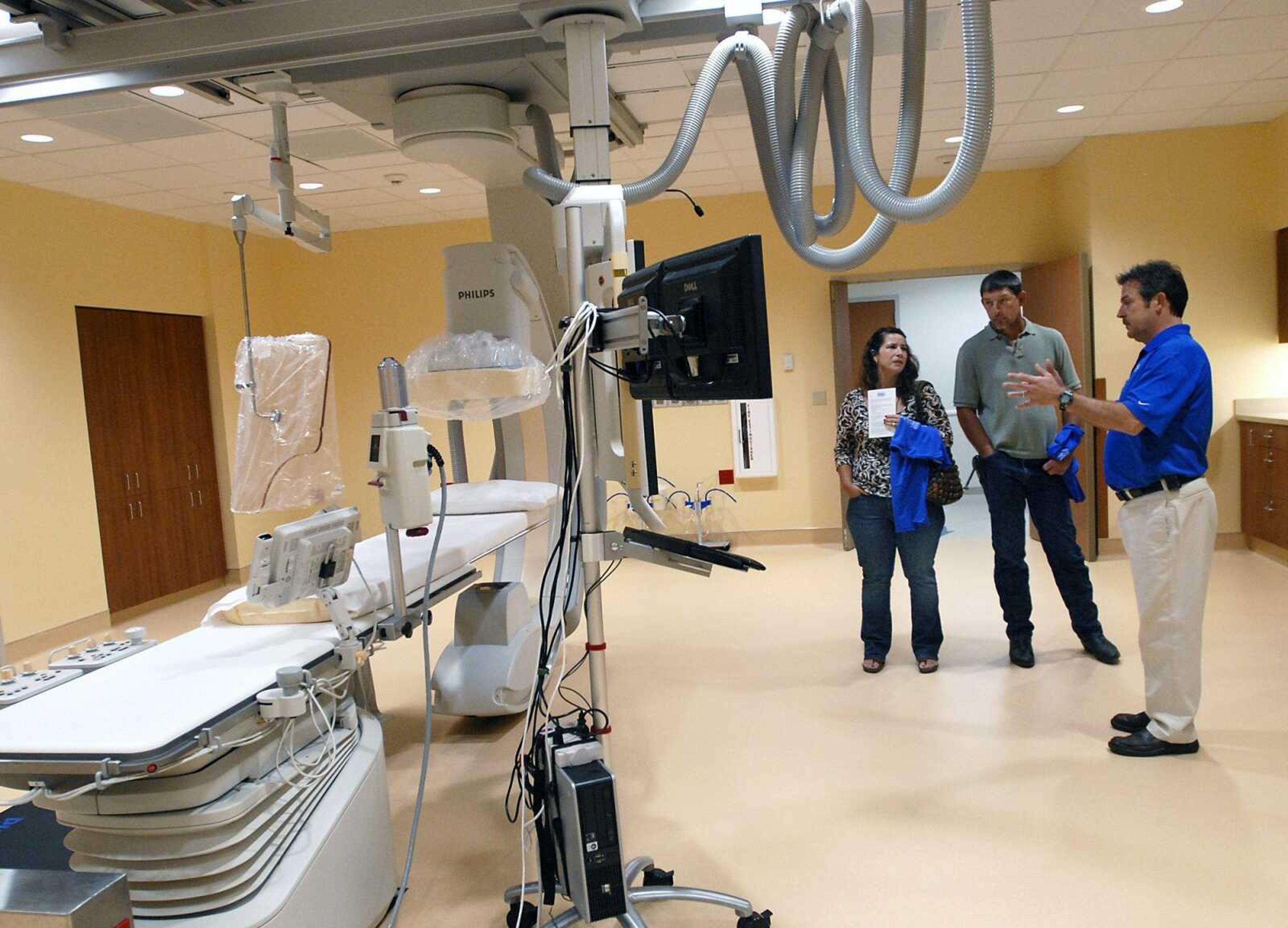 David Stagner, right, director of cardiovascular services, speaks about the new Cath Lab at Saint Francis Medical Center with Travis and Lori Aufdenberg. On Saturday, Saint Francis held a construction crew and family open house for its Heart Hospital and Cancer Institute, which is scheduled to open in July. For more photos, visit semissourian.com. (Kristin Eberts)