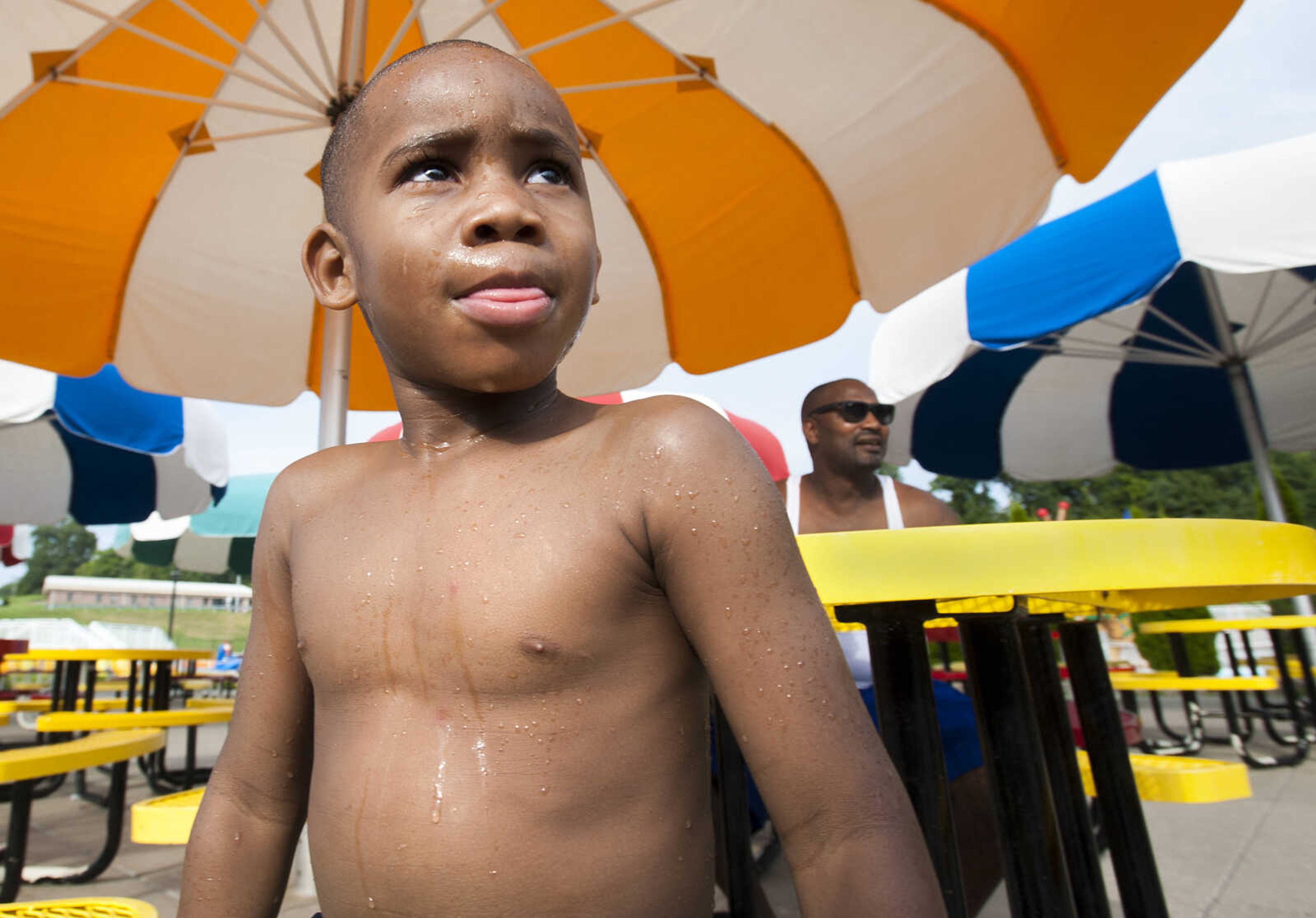 Tylan Mack, 4, sits at the concessions area with his father, Tyrone, after swimming Sunday, Aug. 11, 2019, at Cape Splash in Cape Girardeau.