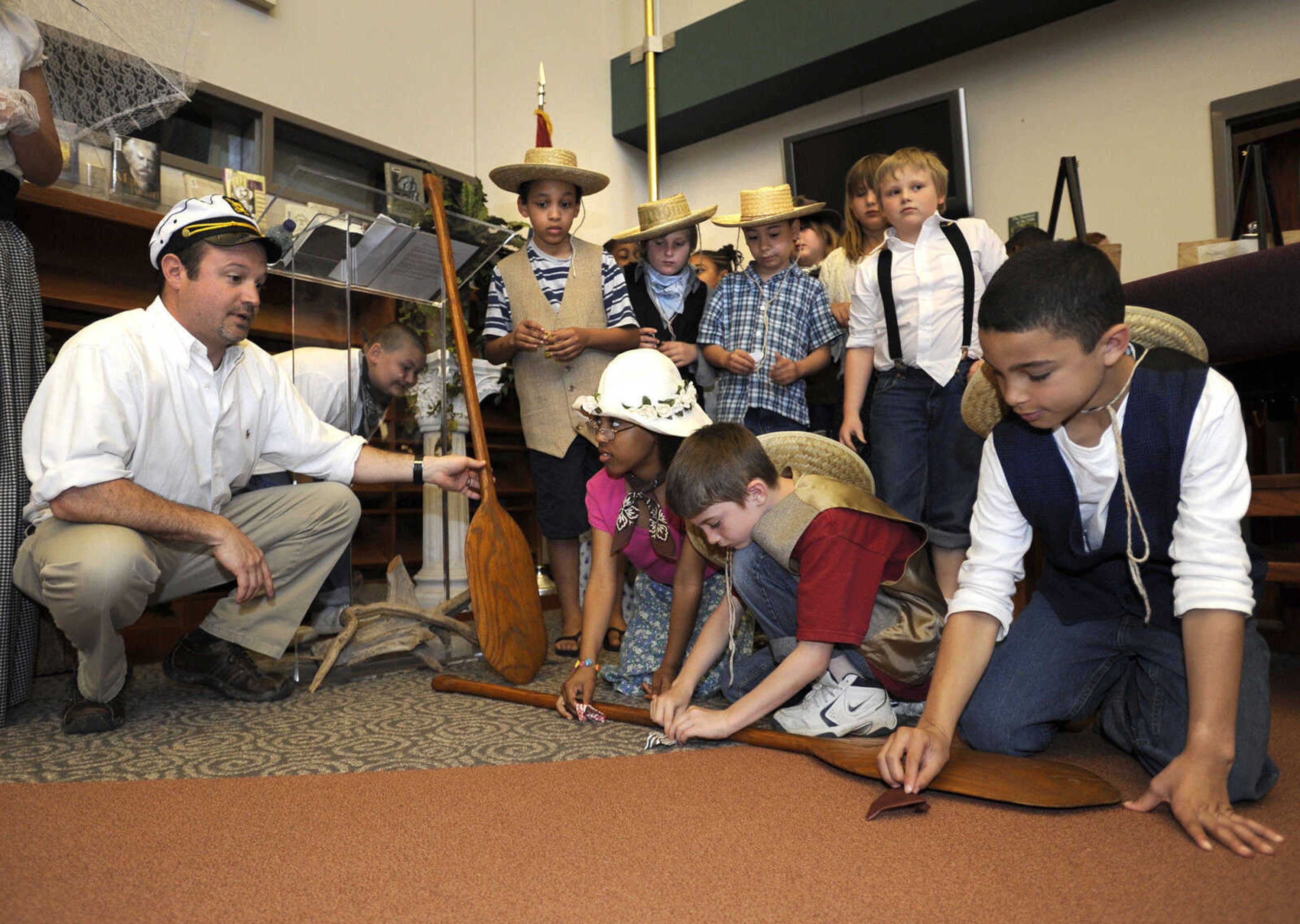 FRED LYNCH ~ flynch@semissourian.com
Nebraska riverboat pilot Josh Crowell, left, conducts a paper jumping frog contest with third-grade students from Jefferson Elementary School during the Mark Twain Centennial event Tuesday at Central High School.