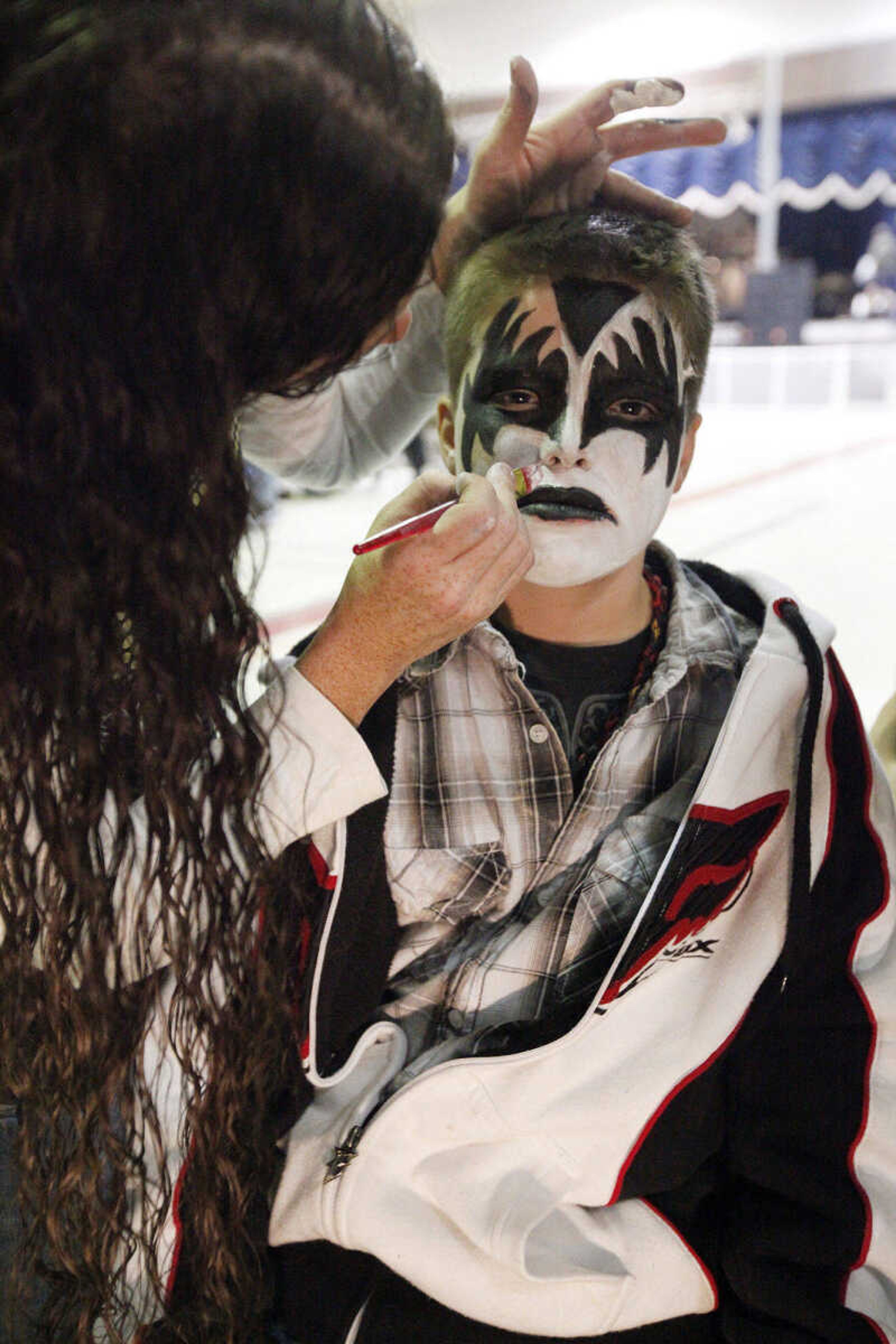 CHRIS MACKLER ~ photos@semissourian.com

Connor Klein, 12, gets his face painted by Erin Schloss before the Kiss, AC/DC and Rod Stewart Tribute Concert held at the Arena Building on Saturday, Nov. 6, 2010, in Cape Girardeau.