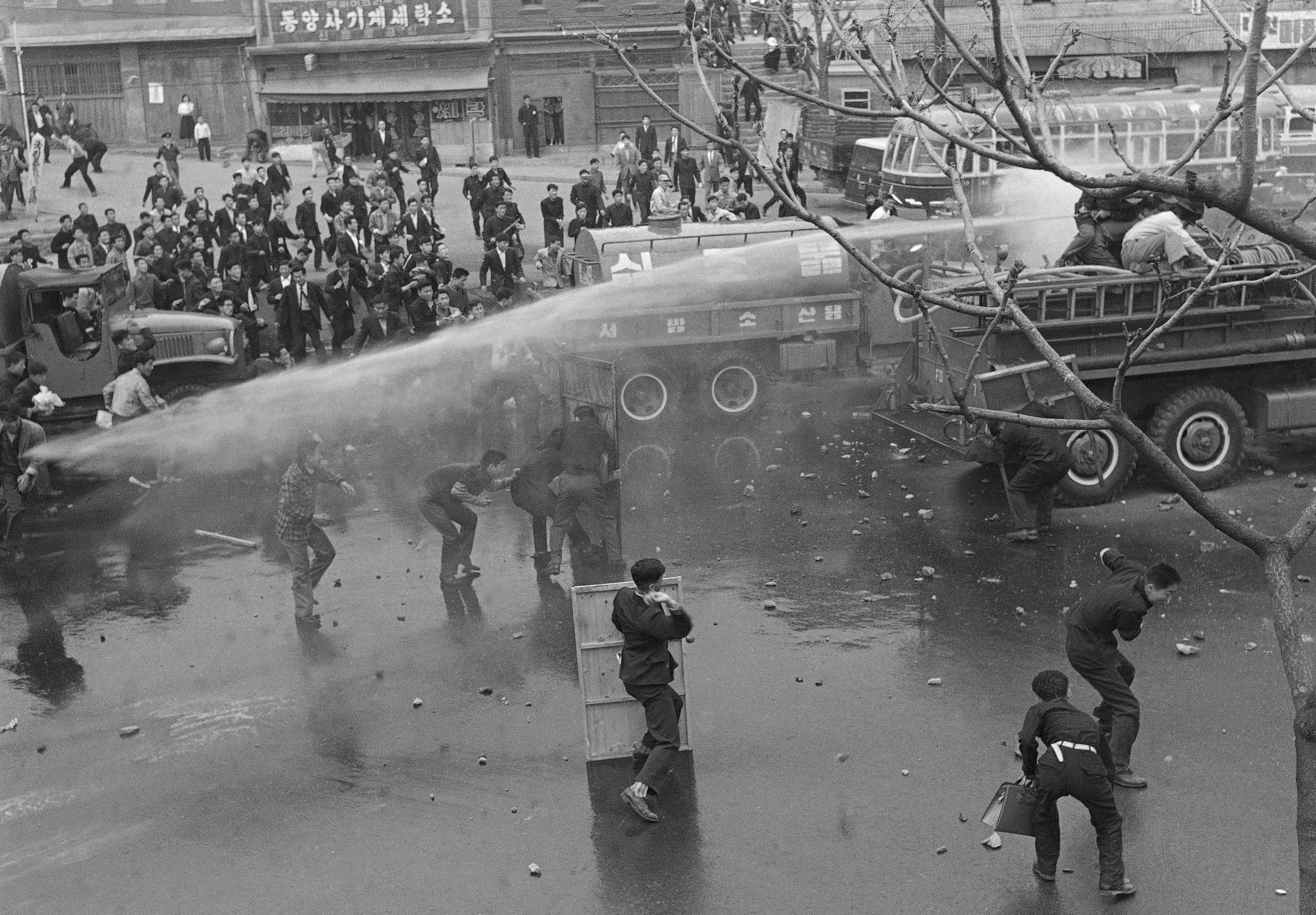 FILE- Students in South Korea capital of Seoul use shield to defy attempts to disperse them with fire hoses on April 19, 1960. Students were protesting manner in which recent election was managed. (AP Photo/Kim Chon Kil, File)