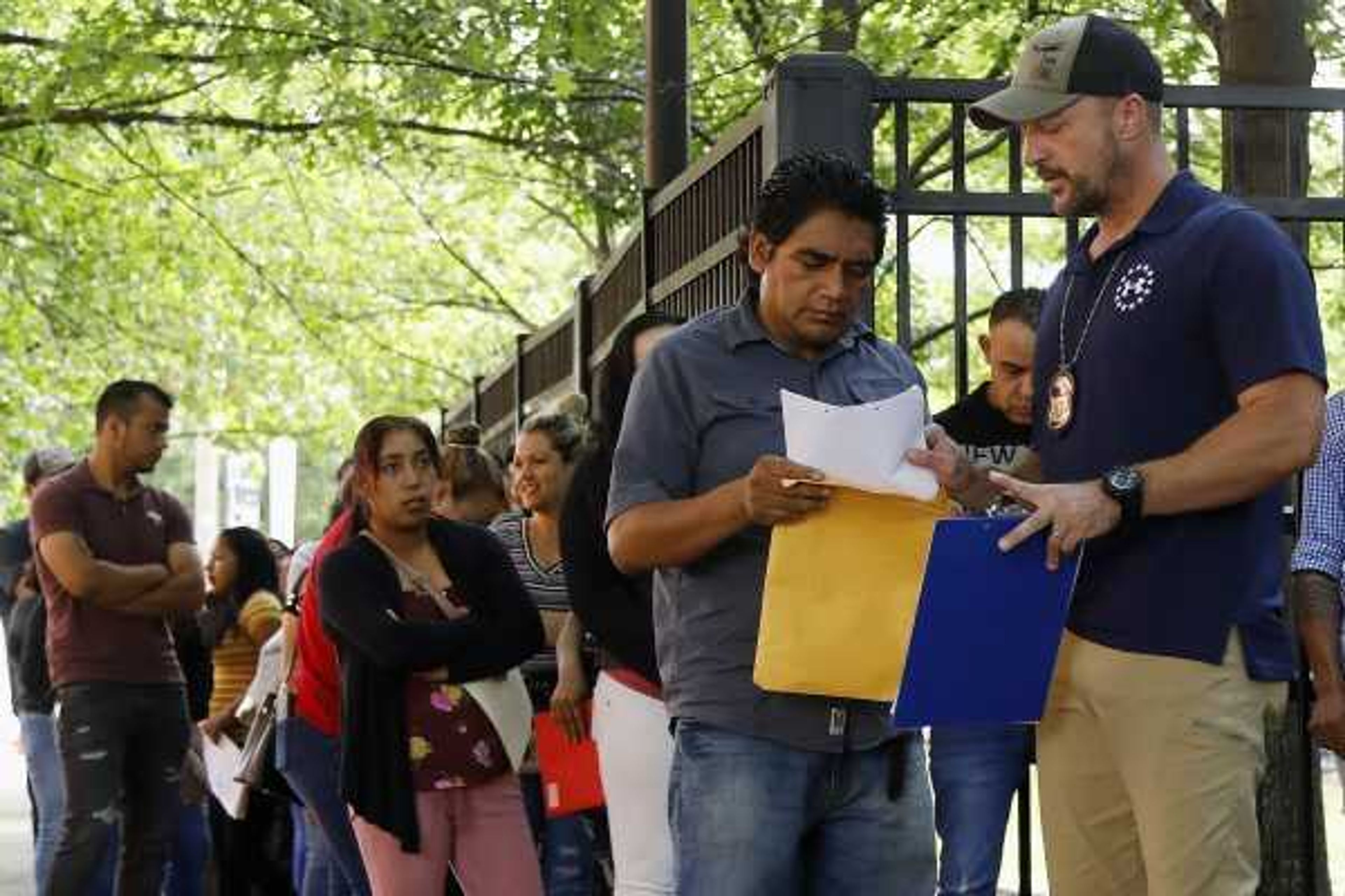 In this June 12, 2019, photo, an Immigration and Customs Enforcement official gives direction to a person outside the building that houses ICE and the immigration court in Atlanta. The Trump administration has appointed more than 4 in 10 of the countryÂ‚Ã„Ã´s sitting immigration judges in a hiring surge that comes as U.S. authorities seek to crack down on immigration. (AP Photo/Andrea Smith)