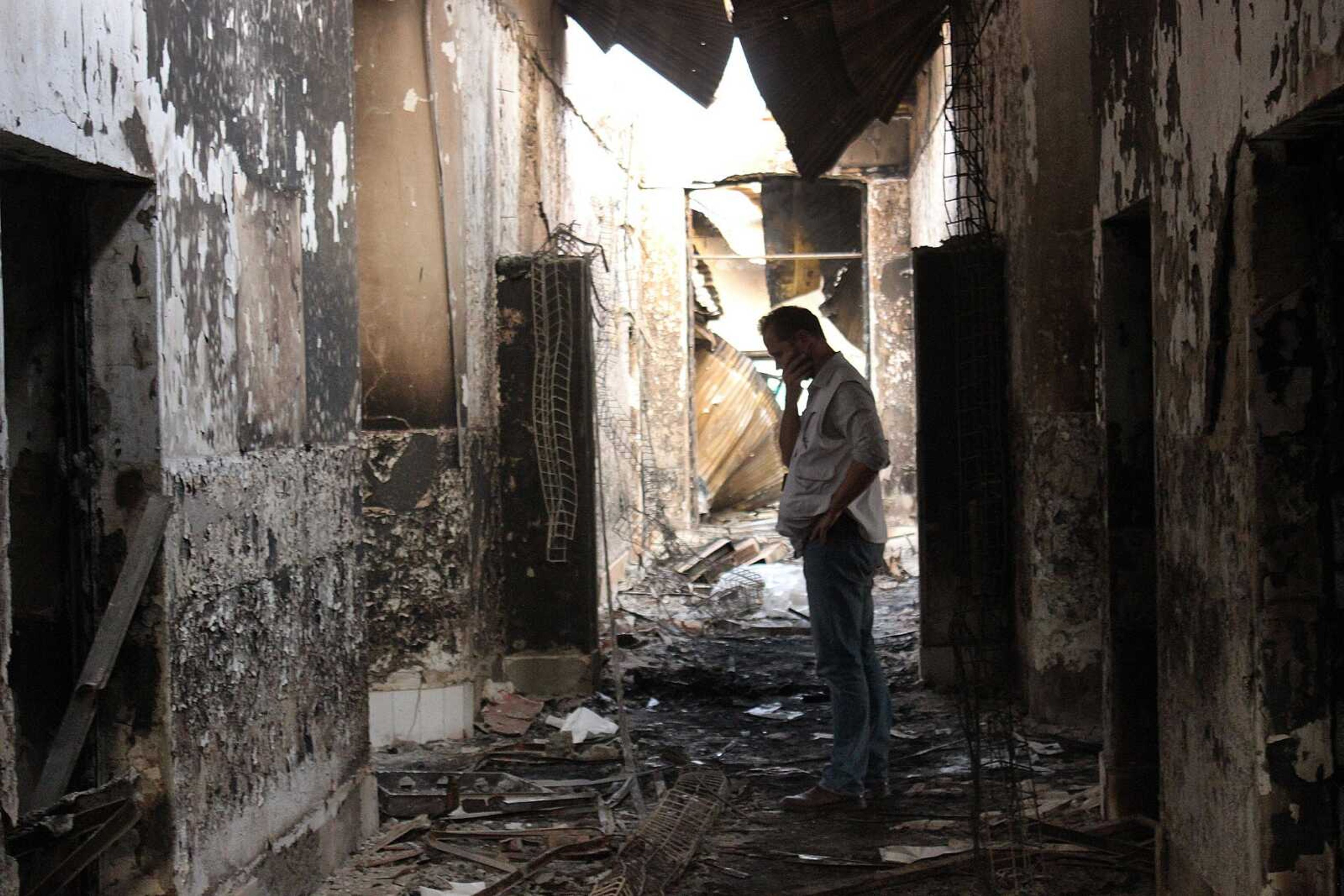 An employee of Doctors Without Borders walks inside the charred remains of their hospital Oct. 16 after it was hit by a U.S. airstrike in Kunduz, Afghanistan. (Najim Rahim via AP)