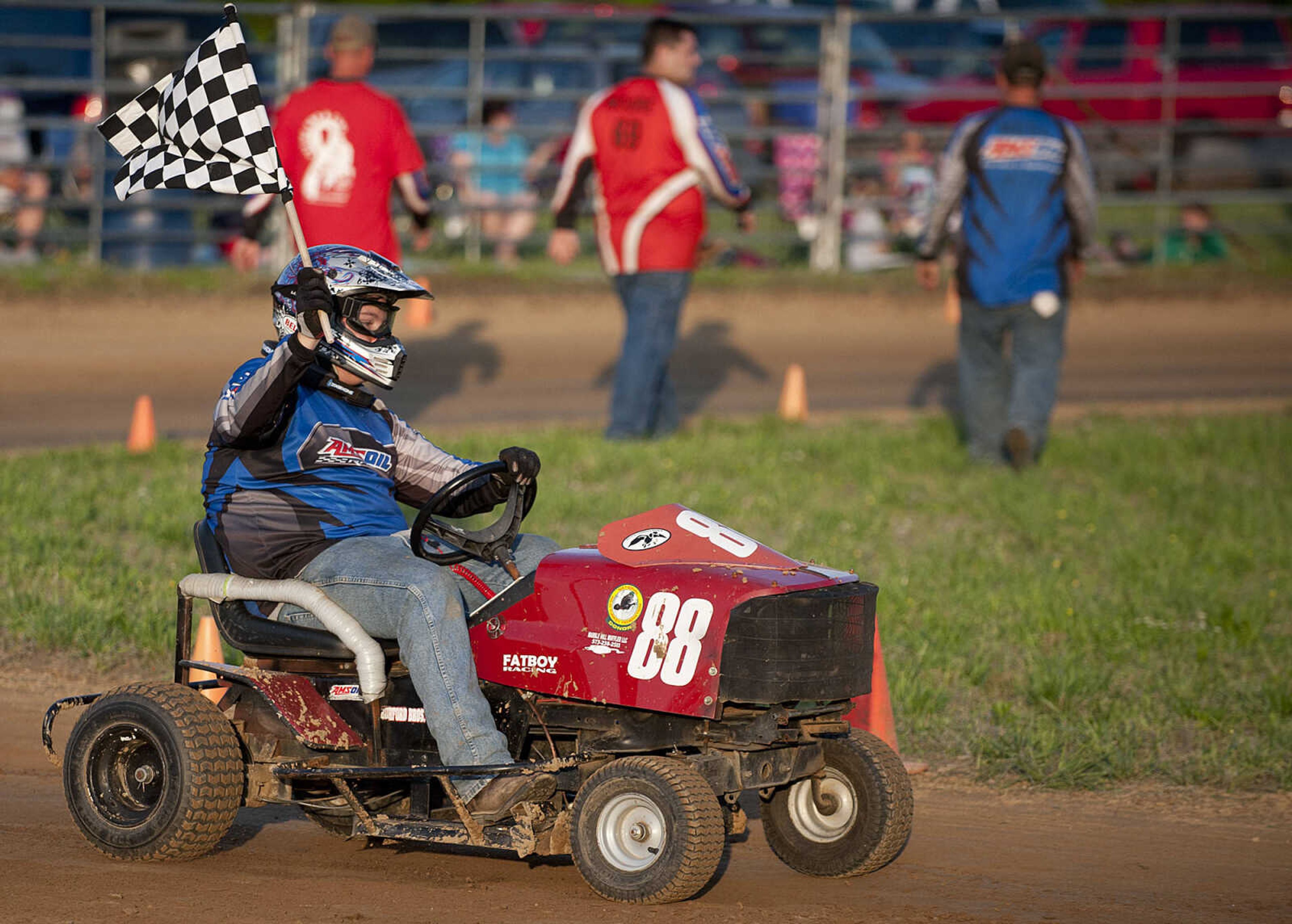 Justin Lawson, 16, takes the checkers flag in the C Class heat during the Southeast Missouri Lawnmower Racing Association's Racing for a Cure presented by the Patton Lions Club at the Patton Saddle Club Saturday, May 10, in Patton, Mo.