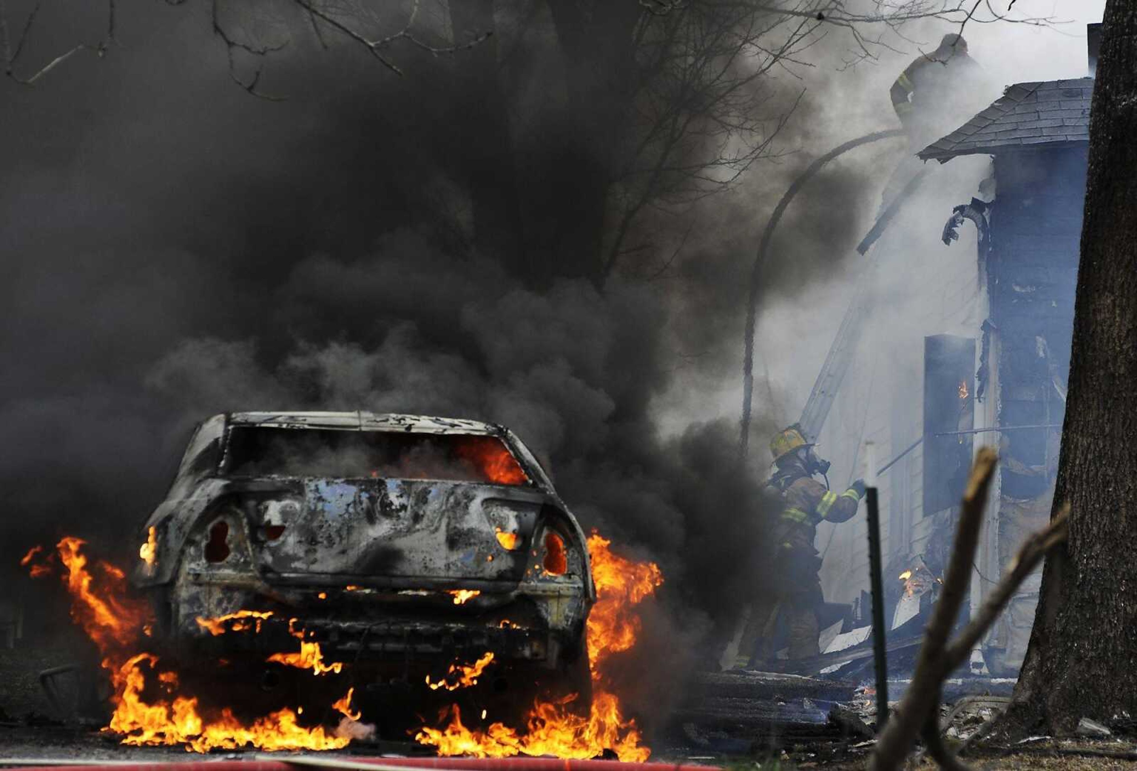 A car burns as firefighters battle a blaze at 429 E., Olive St., in Scott City Monday, March 4. Members of the Scott City, Cape Girardeau and Chaffee fire departments responded to the scene of the fire which destroyed the house, a shed and a neighbor's car. (Adam Vogler)