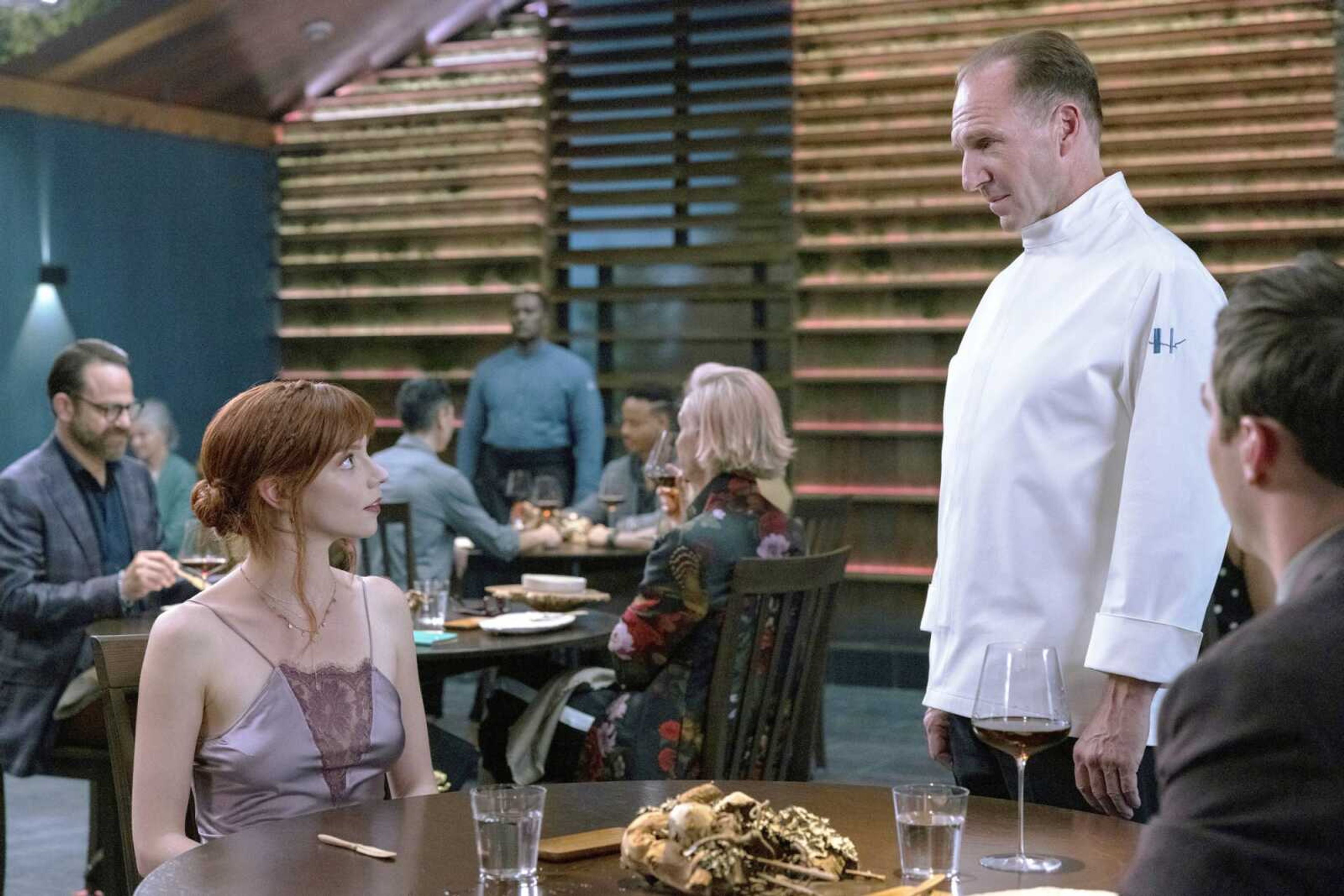 This image released by Searchlight Pictures shows Ralph Fiennes, right, and Anya Taylor-Joy in a scene from the film "The Menu."