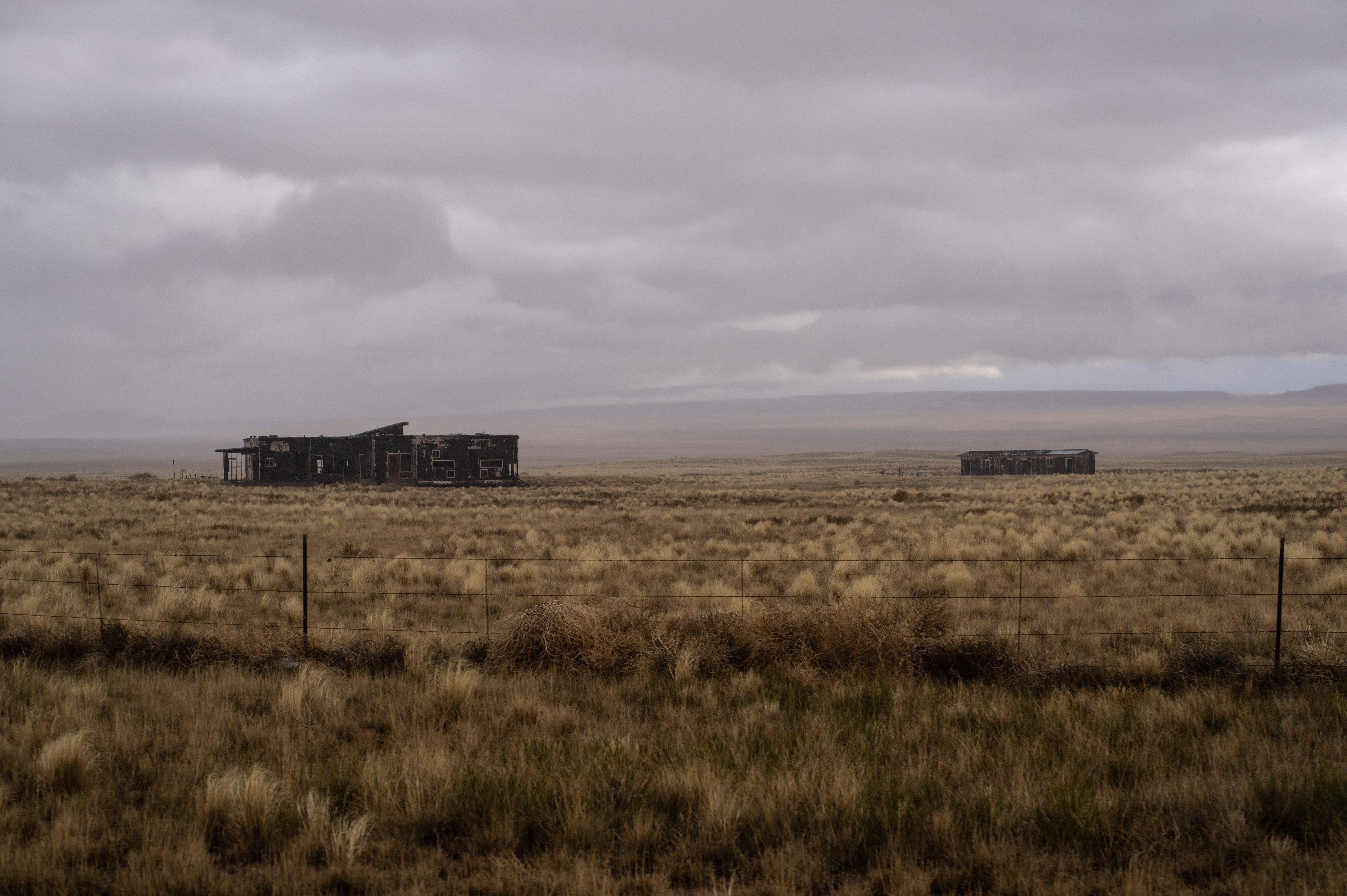 A storm forms over abandoned houses on the Navajo Nation, on the outskirts of Tuba City, Ariz., Friday, Oct. 18, 2024.(AP Photo/Rodrigo Abd)