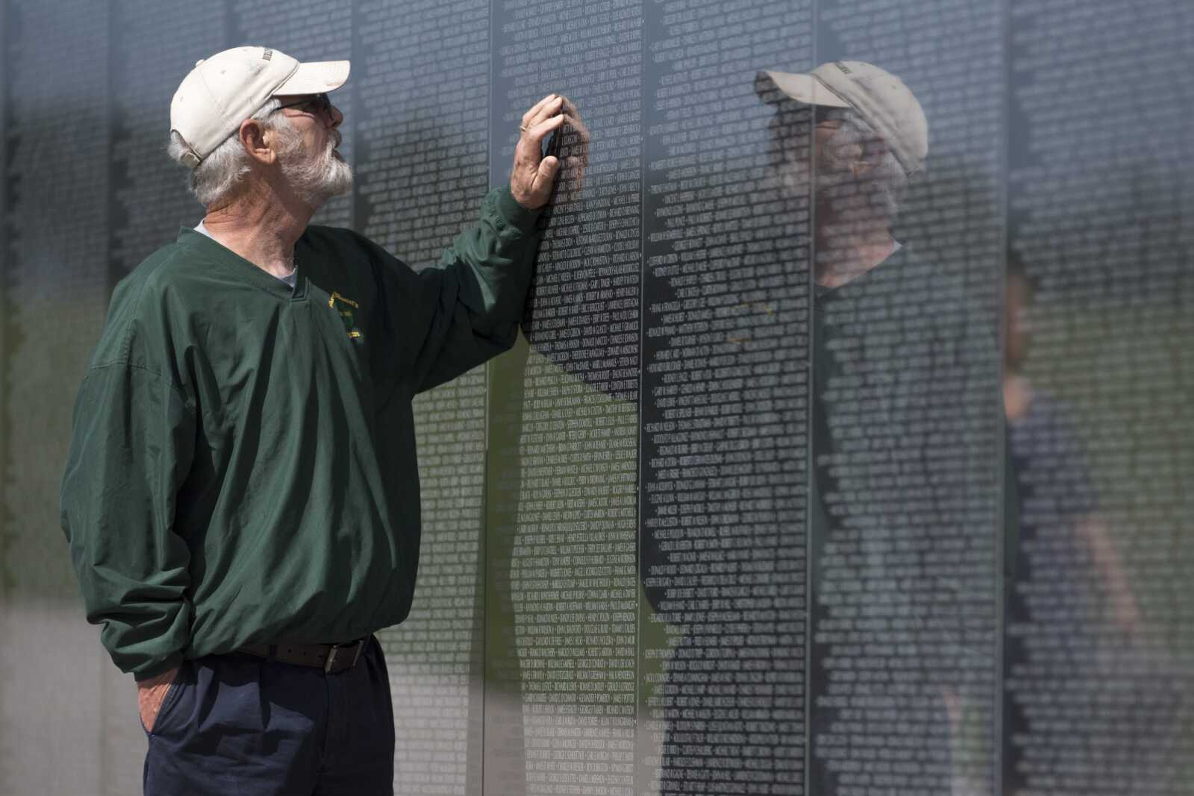 Army veteran Tom Arens of St. Louis touches an inscription on the Missouri's National Veterans Memorial bearing the name of his friend Samuel V. Burruano during Memorial Day on Monday in Perryville. Arens served in Berlin, and paid respects to friends from Ritenour High School in St. Louis.