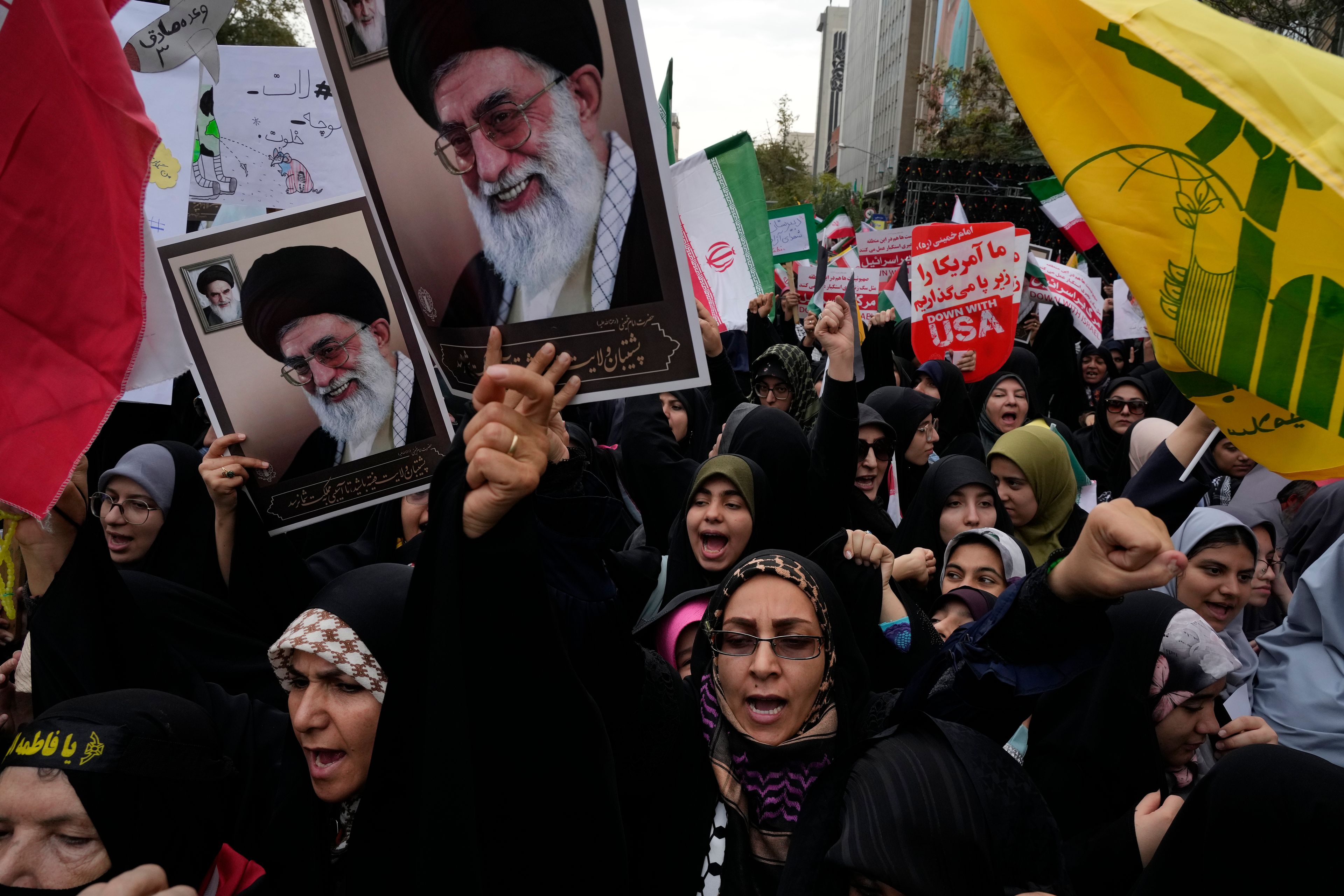 Holding posters of the Iranian Supreme Leader Ayatollah Ali Khamenei and Lebanon's Hezbollah flag, demonstrators chant slogans in an annual rally in front of the former U.S. Embassy in Tehran, Iran, Sunday, Nov. 3, 2024, marking the 45th anniversary of Iranian students' takeover of the embassy, starting a hostage crisis. (AP Photo/Vahid Salemi)