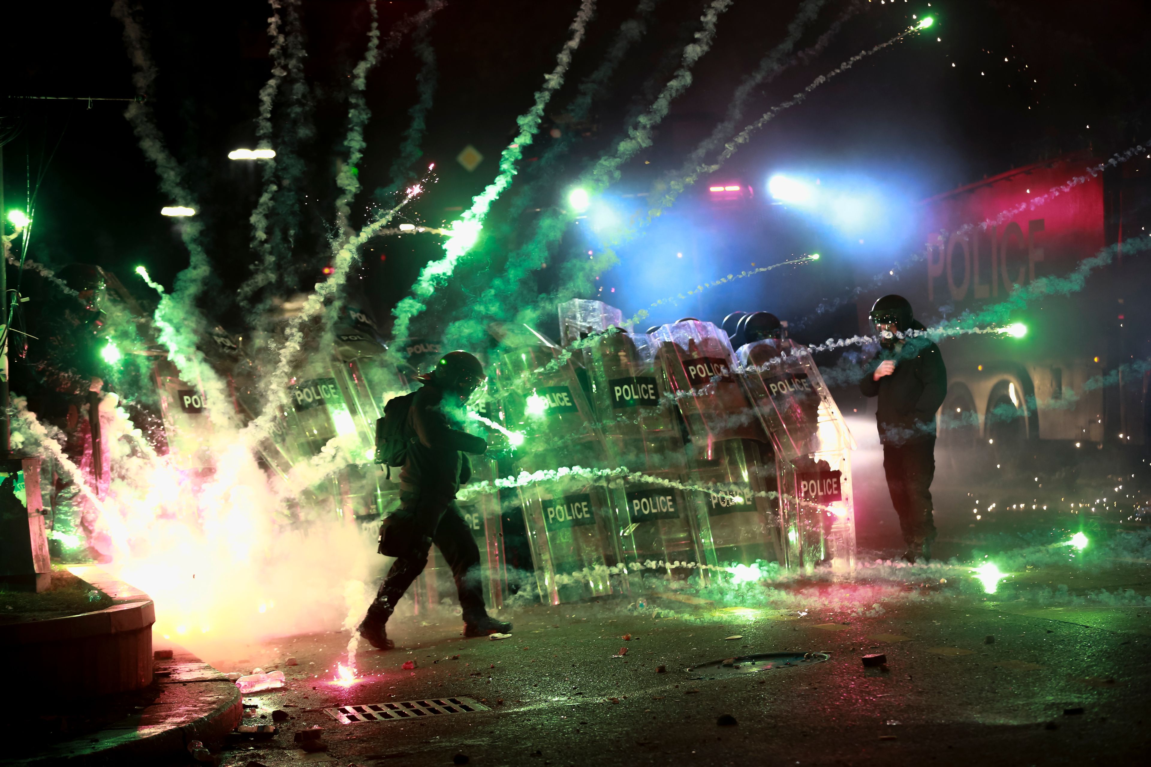 Demonstrators use firecrackers against police as police block a street to prevent protesters rallying against the government's decision to suspend negotiations on joining the European Union for four years, outside the parliament's building in Tbilisi, Georgia, early Saturday, Nov. 30, 2024. (AP Photo/Zurab Tsertsvadze)